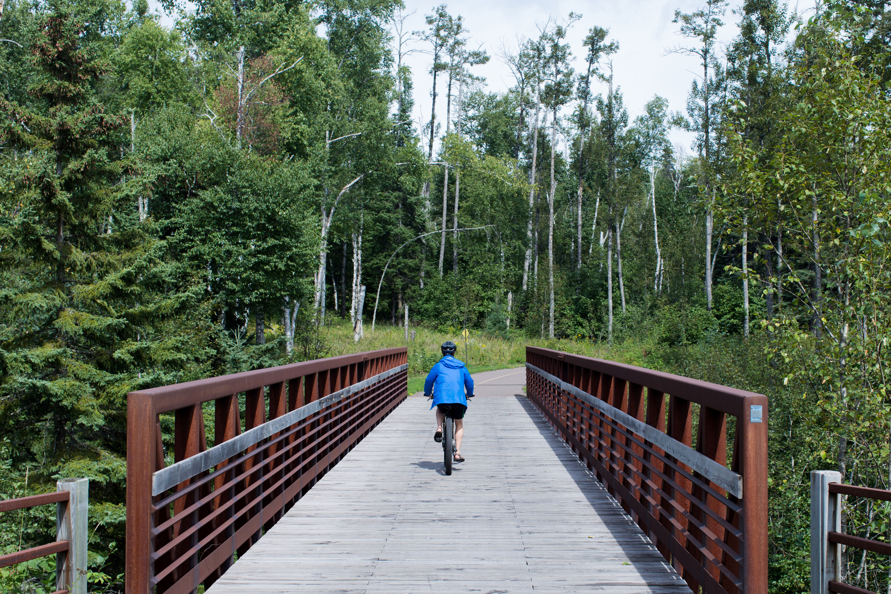 Bicyclist rides across a bridge on the Gitchi-Gami State Trail
