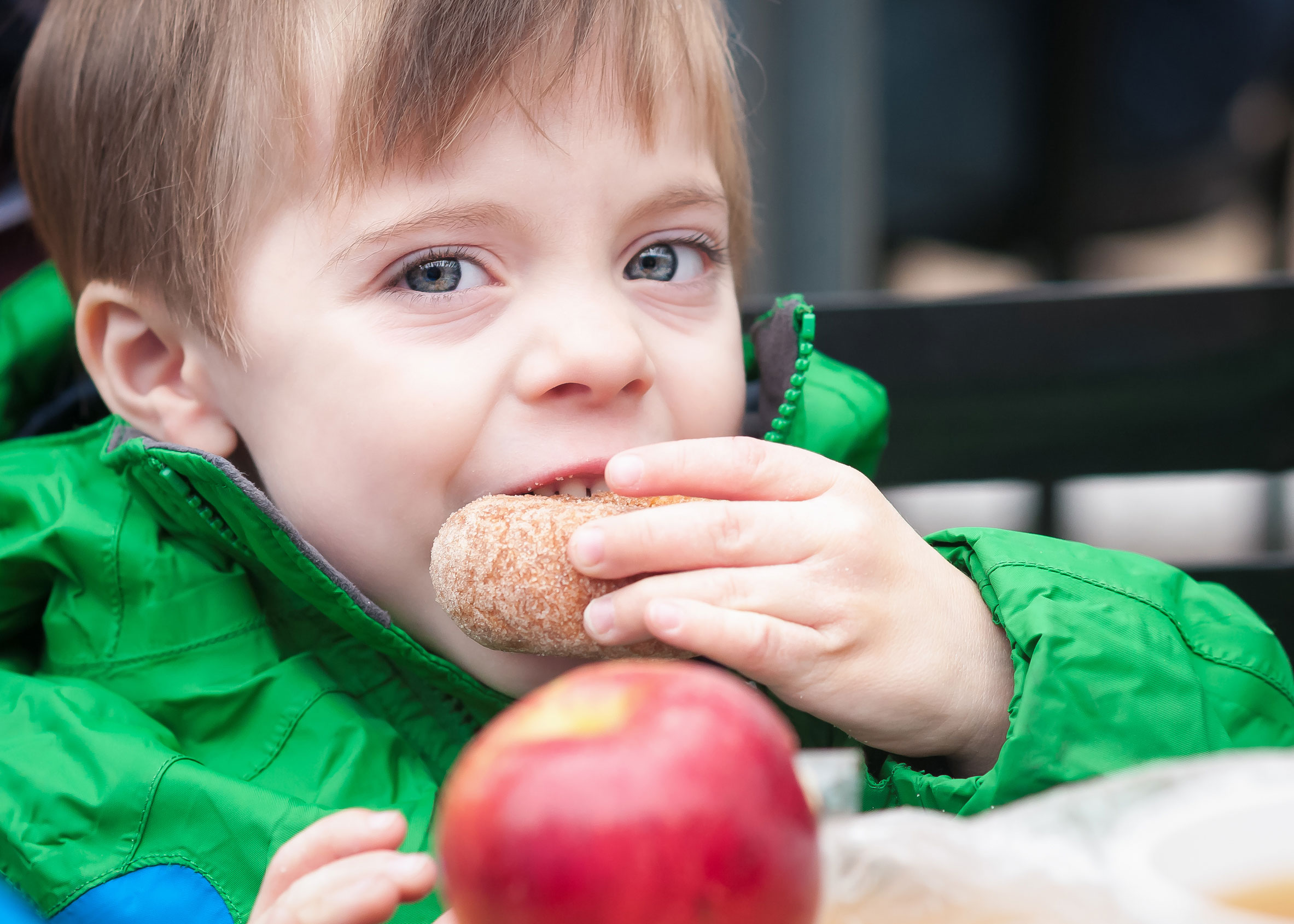 Niño comiendo dona de sidra de manzana