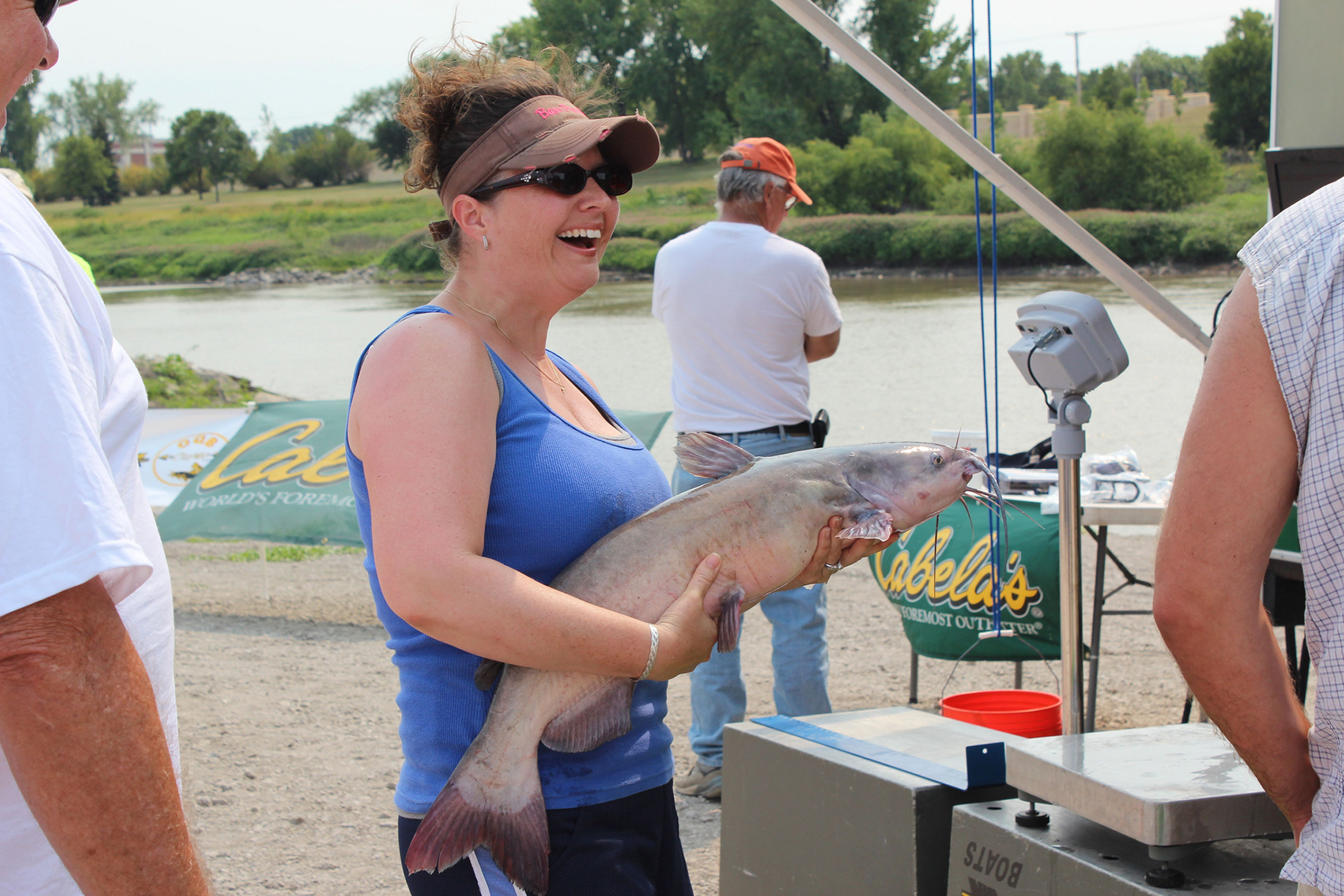 Woman holds a catfish during a Catfish Tournament on the Red River