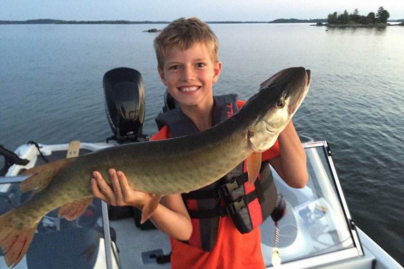 Boy holding a giant muskie on Lake of the Woods