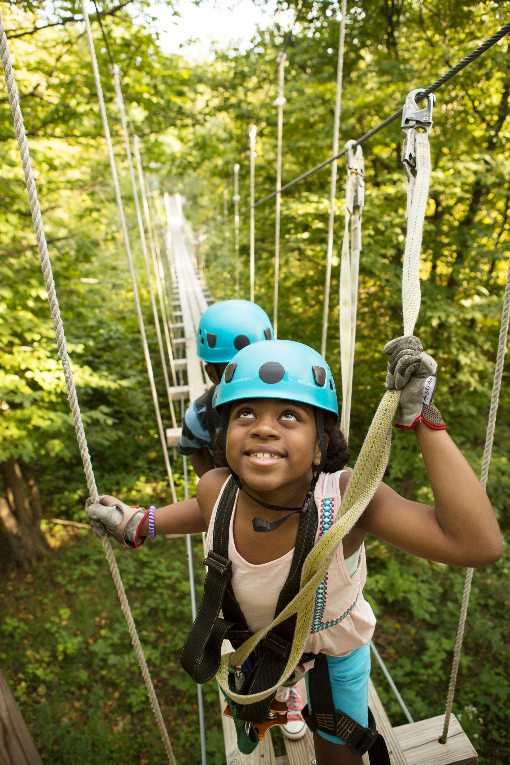 Girl on zip line suspension bridge