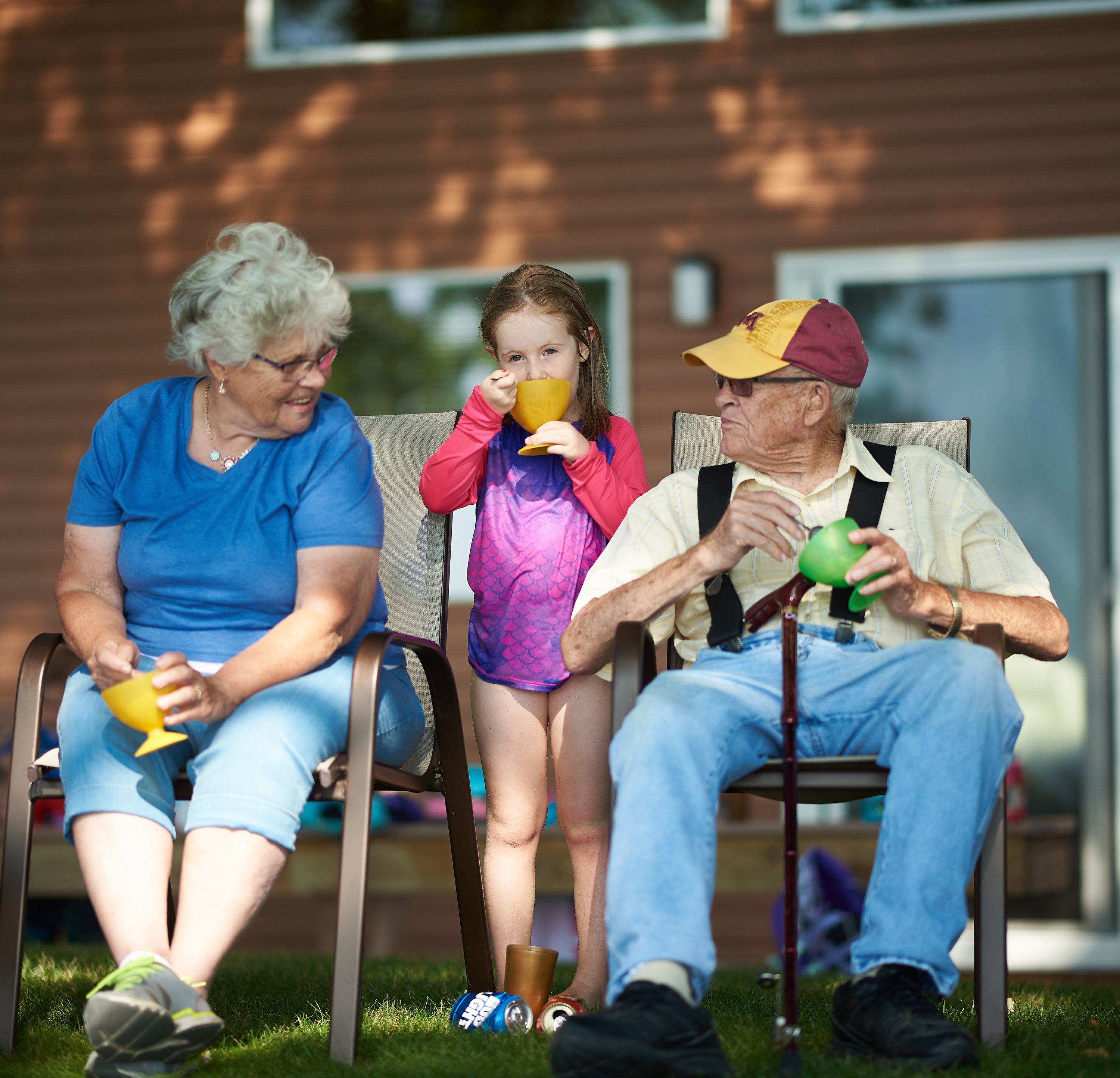 Grandparents and granddaughter eat ice cream outside