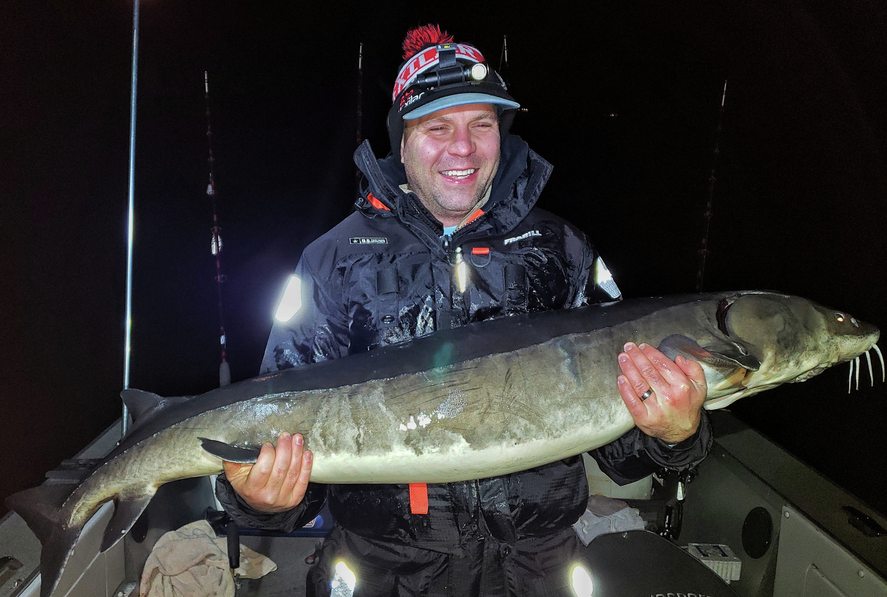 Man holds 61-inch lake sturgeon