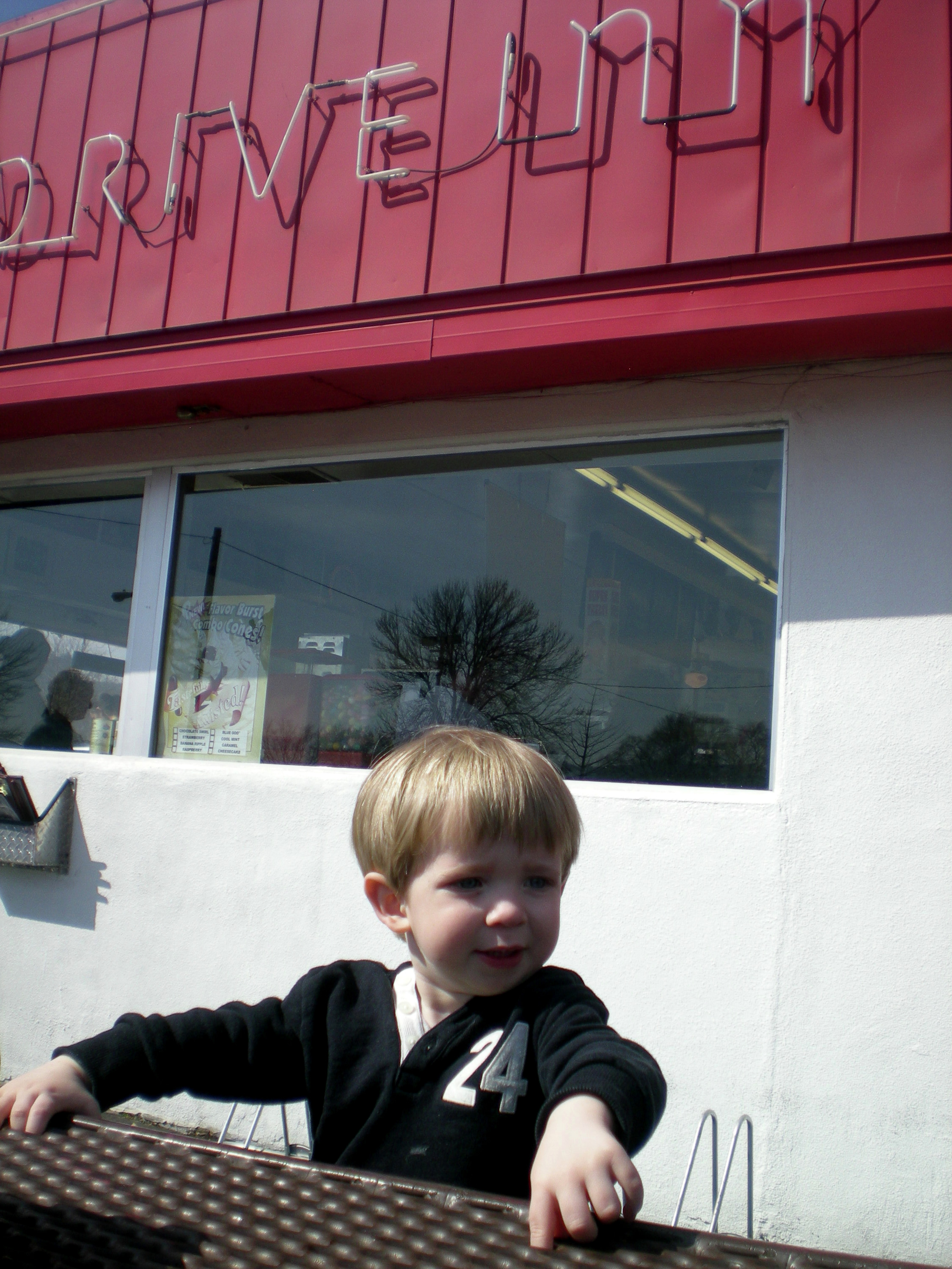 Un niño afuera de un restaurante tipo &quot;drive in&quot;