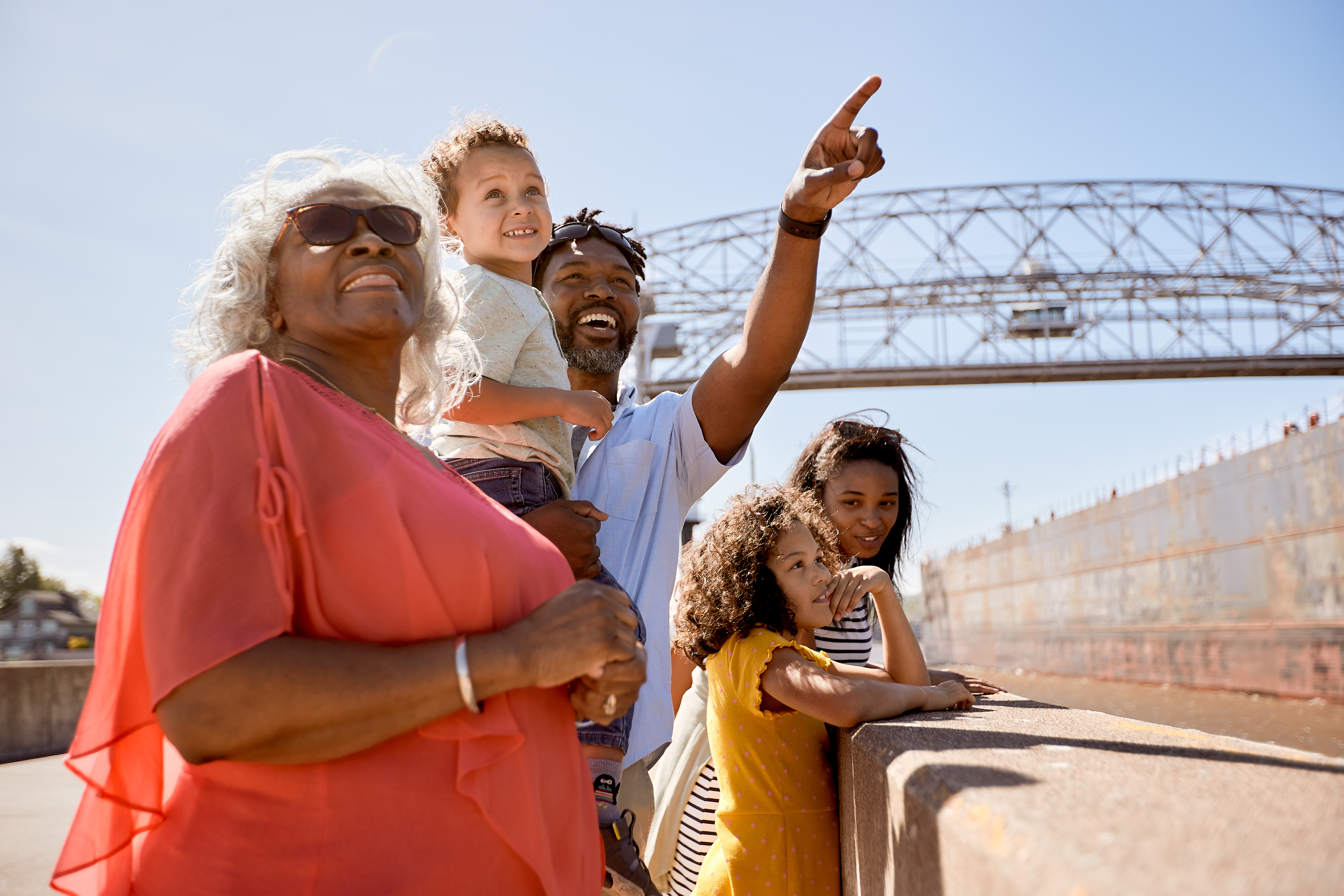 Family on the Canal Park pier in Duluth, pointing toward something in the distance