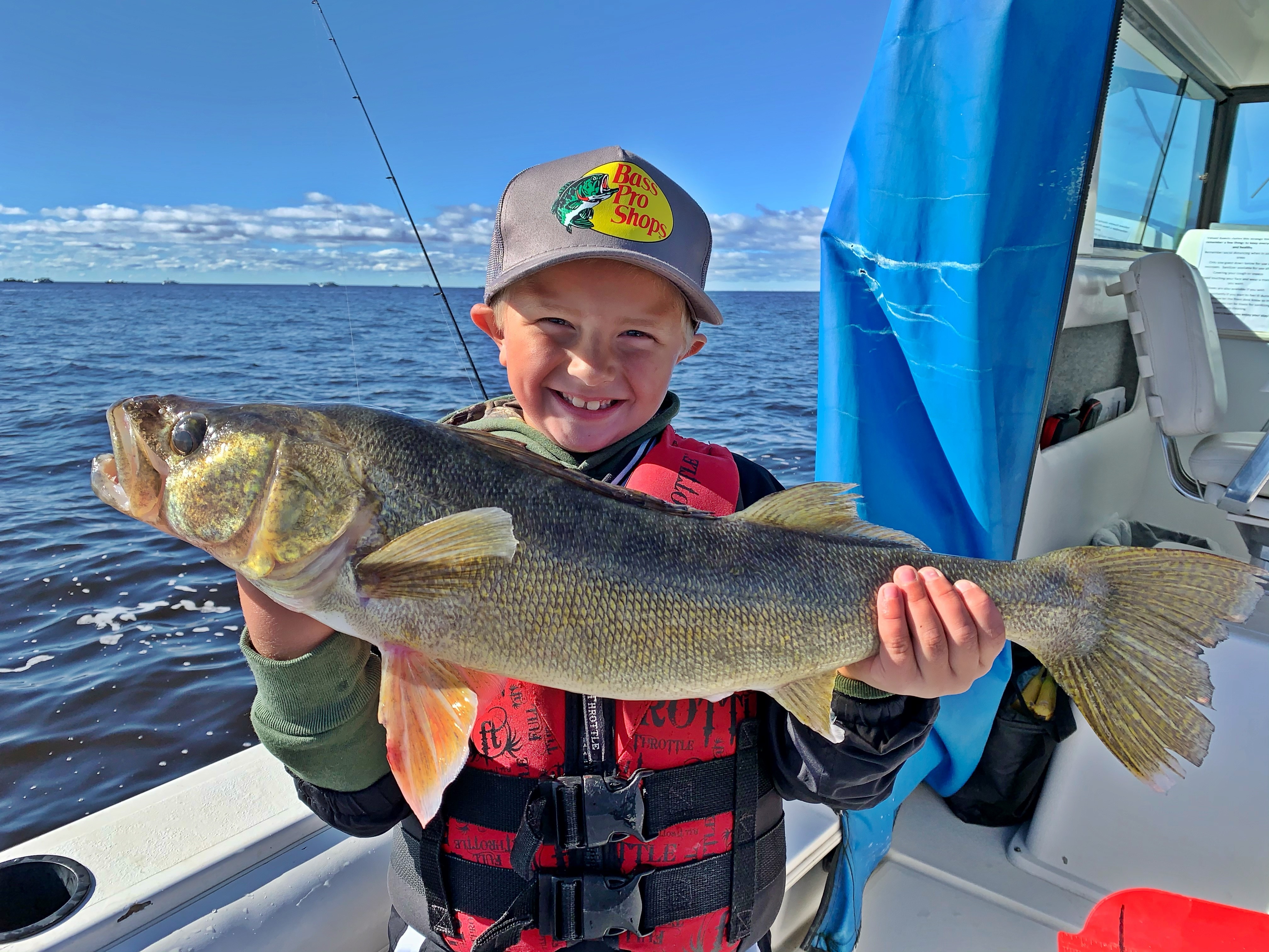 A young boy catches a large walleye when fishing Lake of the Woods at Slim's Resort