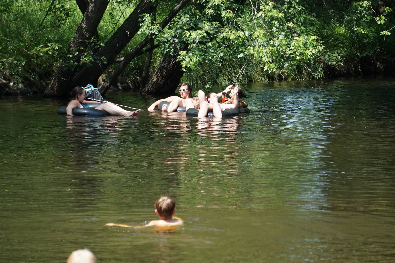 A group of friends relaxes while river tubing on the Platte River