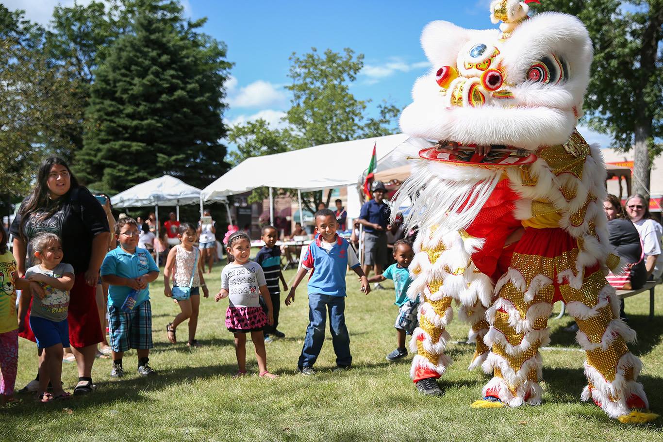 A group of kids watching a Chinese lion dance at the Worthington International Festival