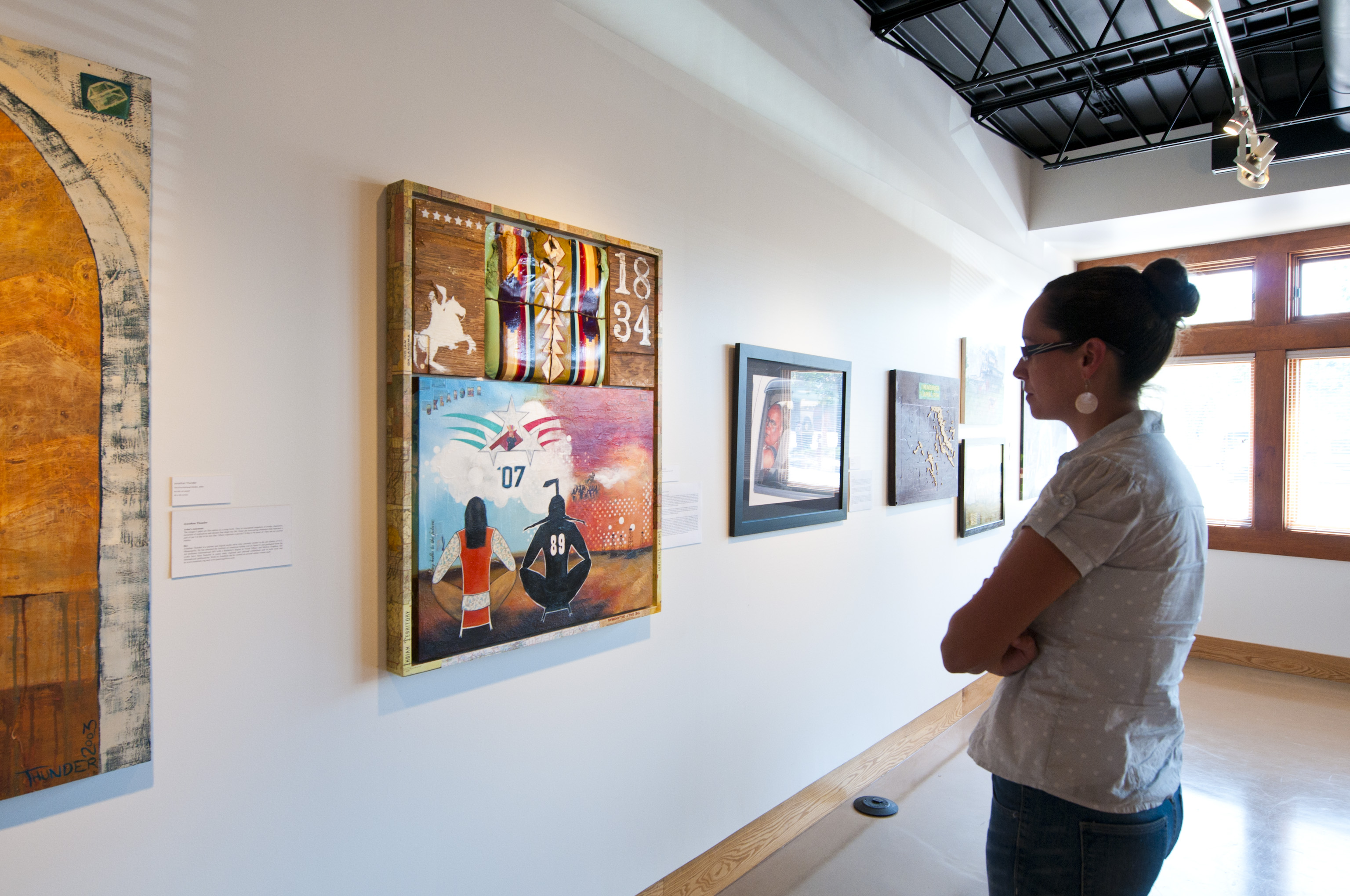 Woman looking at an exhibit at All My Relations Gallery