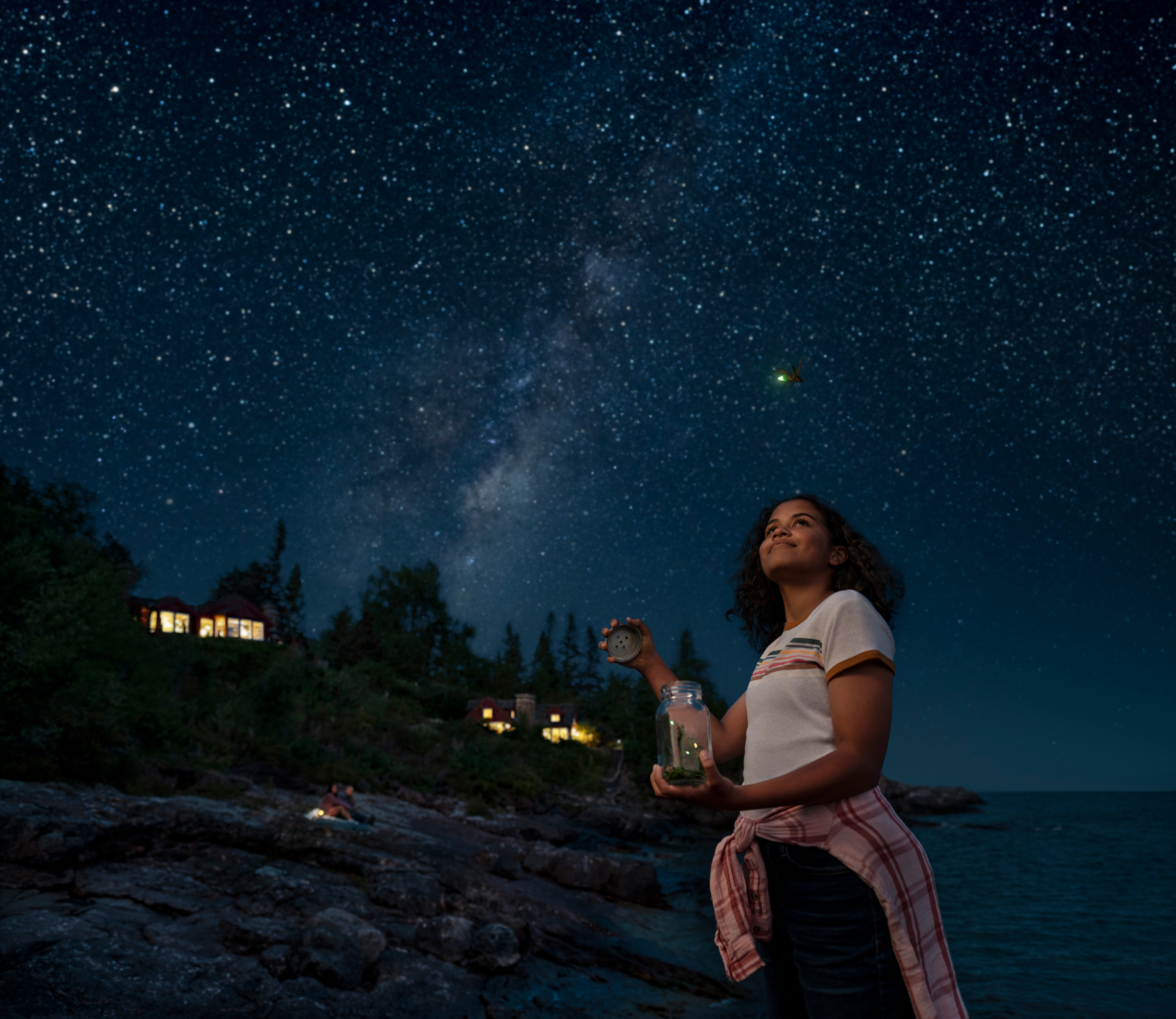 A girl catching fireflies in front of North Shore cabins off Lake Superior