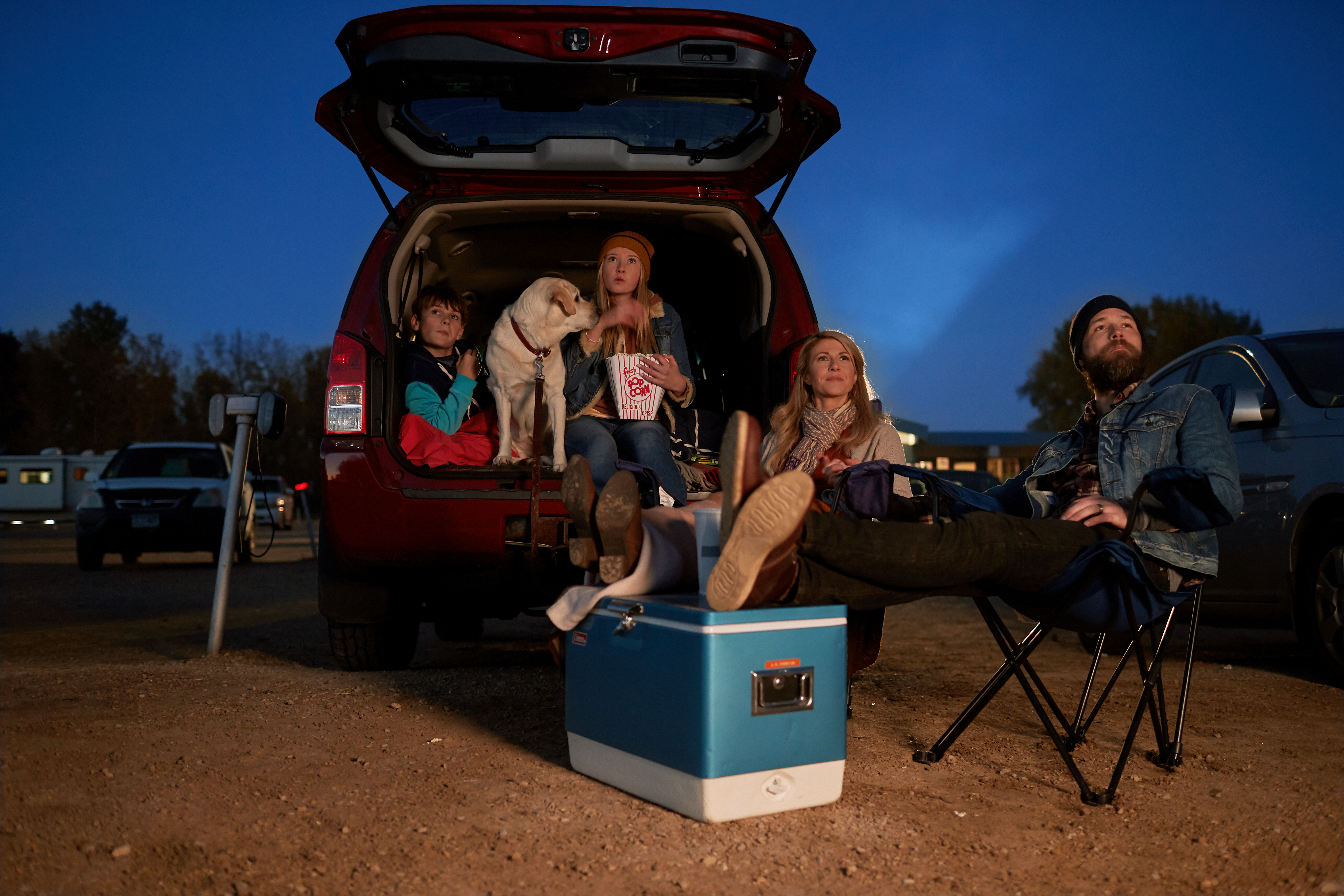 Group of people in back of van set up to watch drive in movie