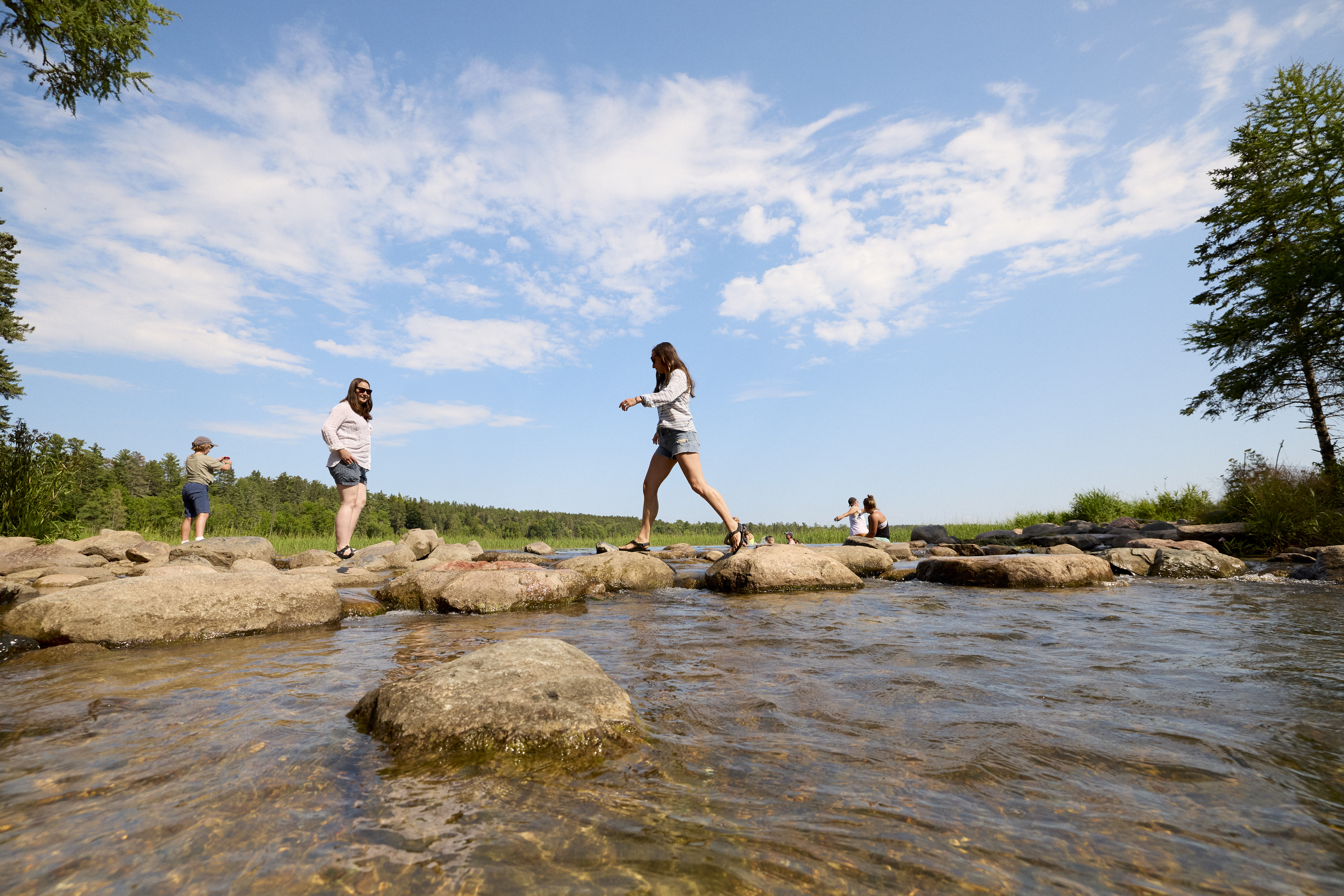 Friends walking along rocks and the Mississippi River in Itasca State Park, Park Rapids