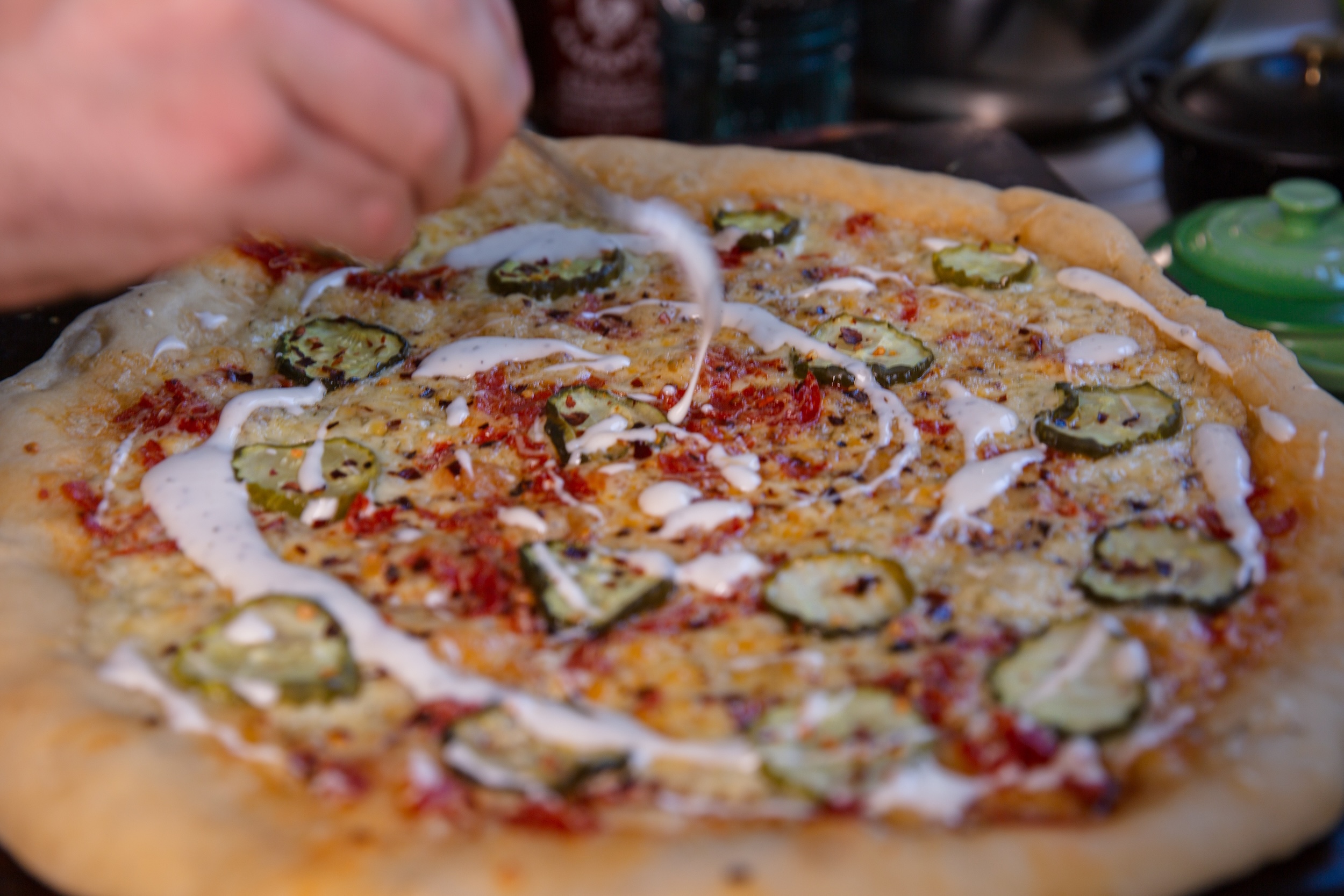 Hayden Haas drizzles ranch on his Dill Pickle Pizza