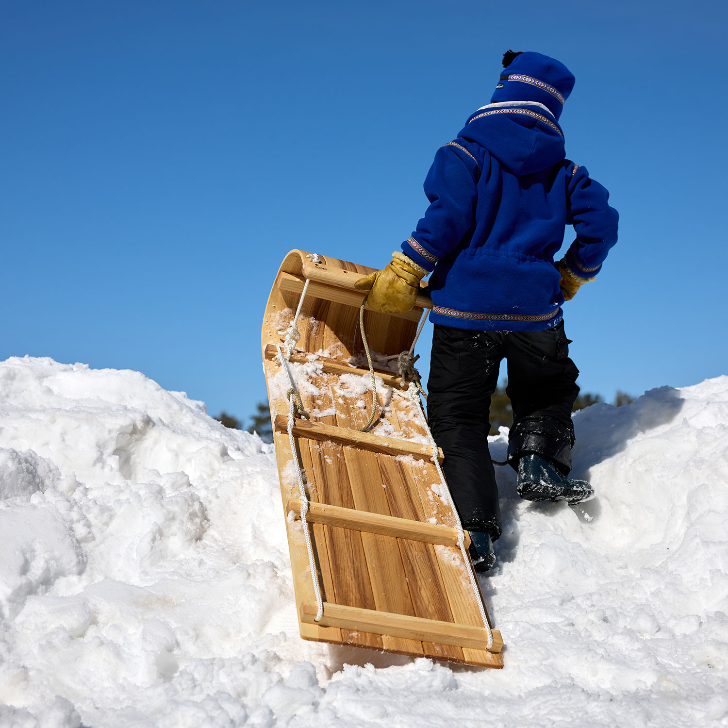 A kid pulls a sled from Northern Toboggan Co