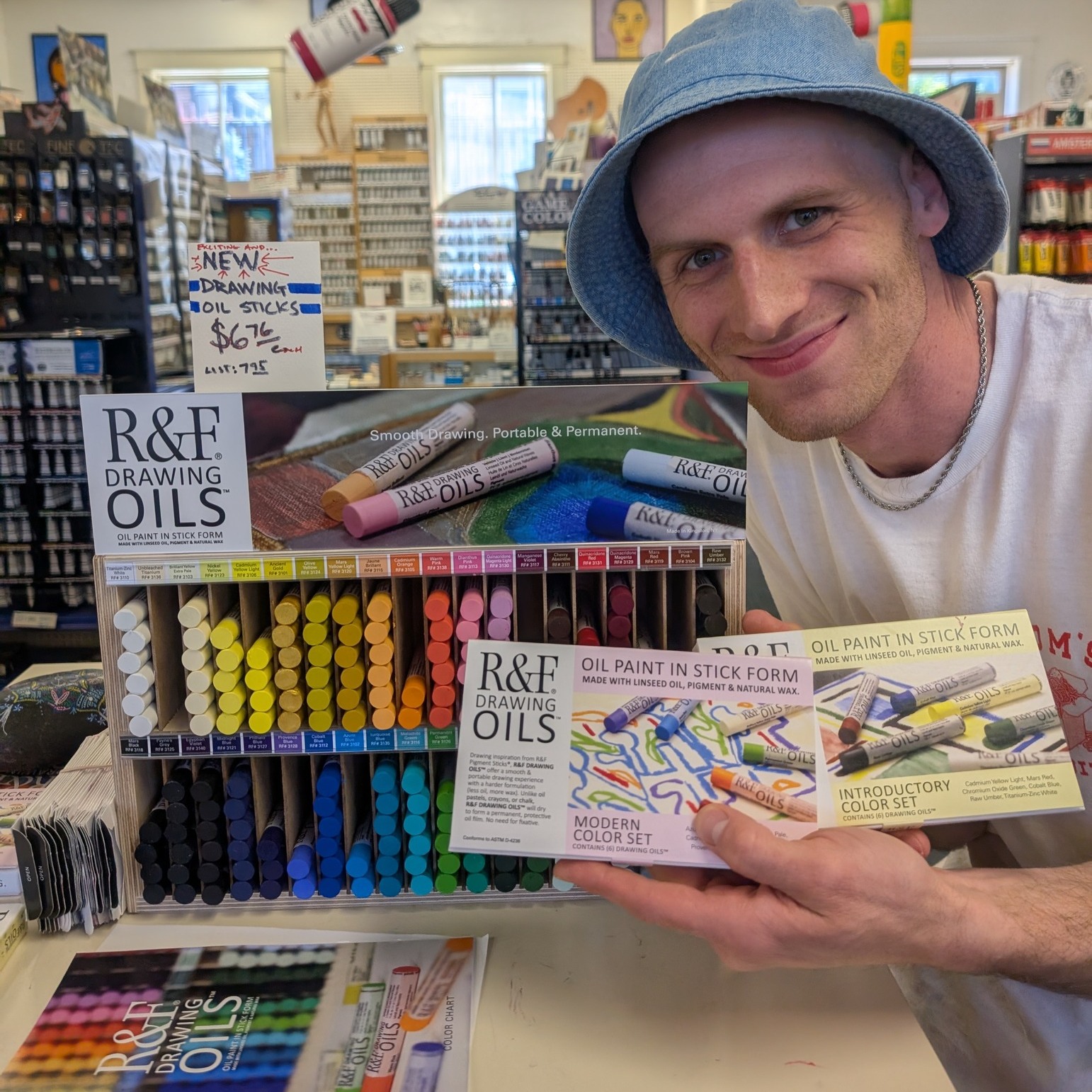 A Wet Paint employee with a R&amp;F Drawing Oils display
