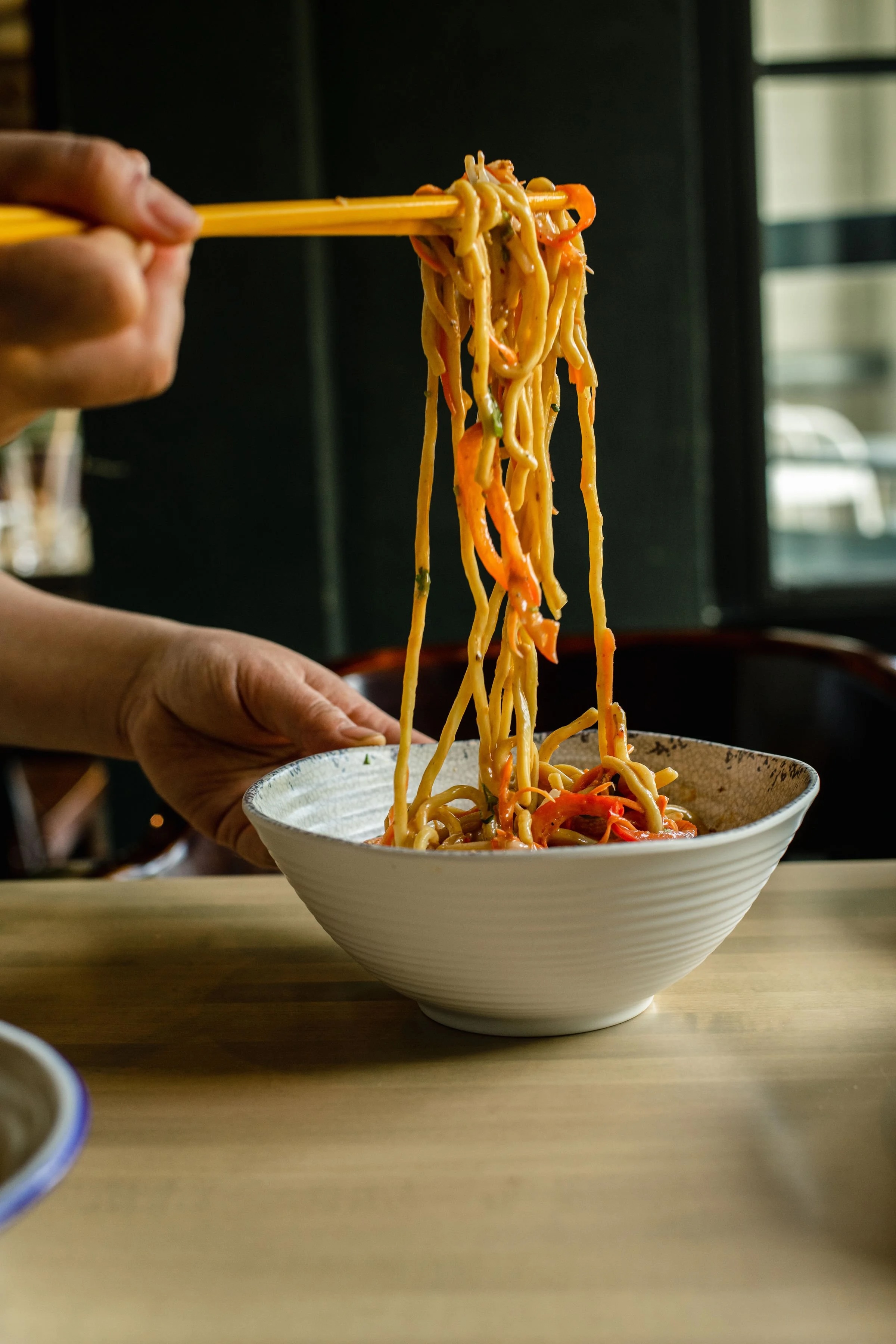 A diner pulls some noodles at Gai Noi
