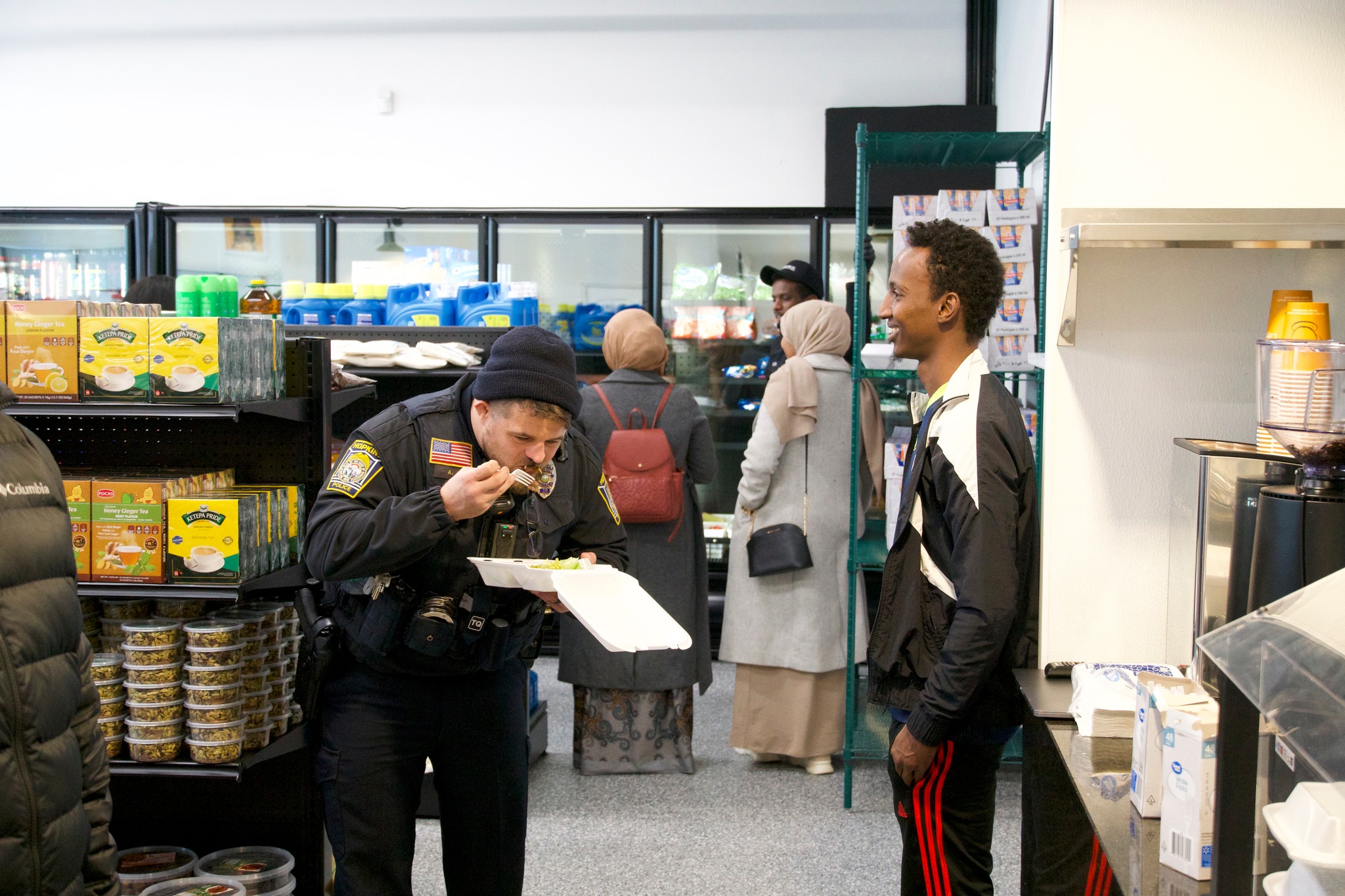 A local police officer samples the Somali food at Gedi Grill