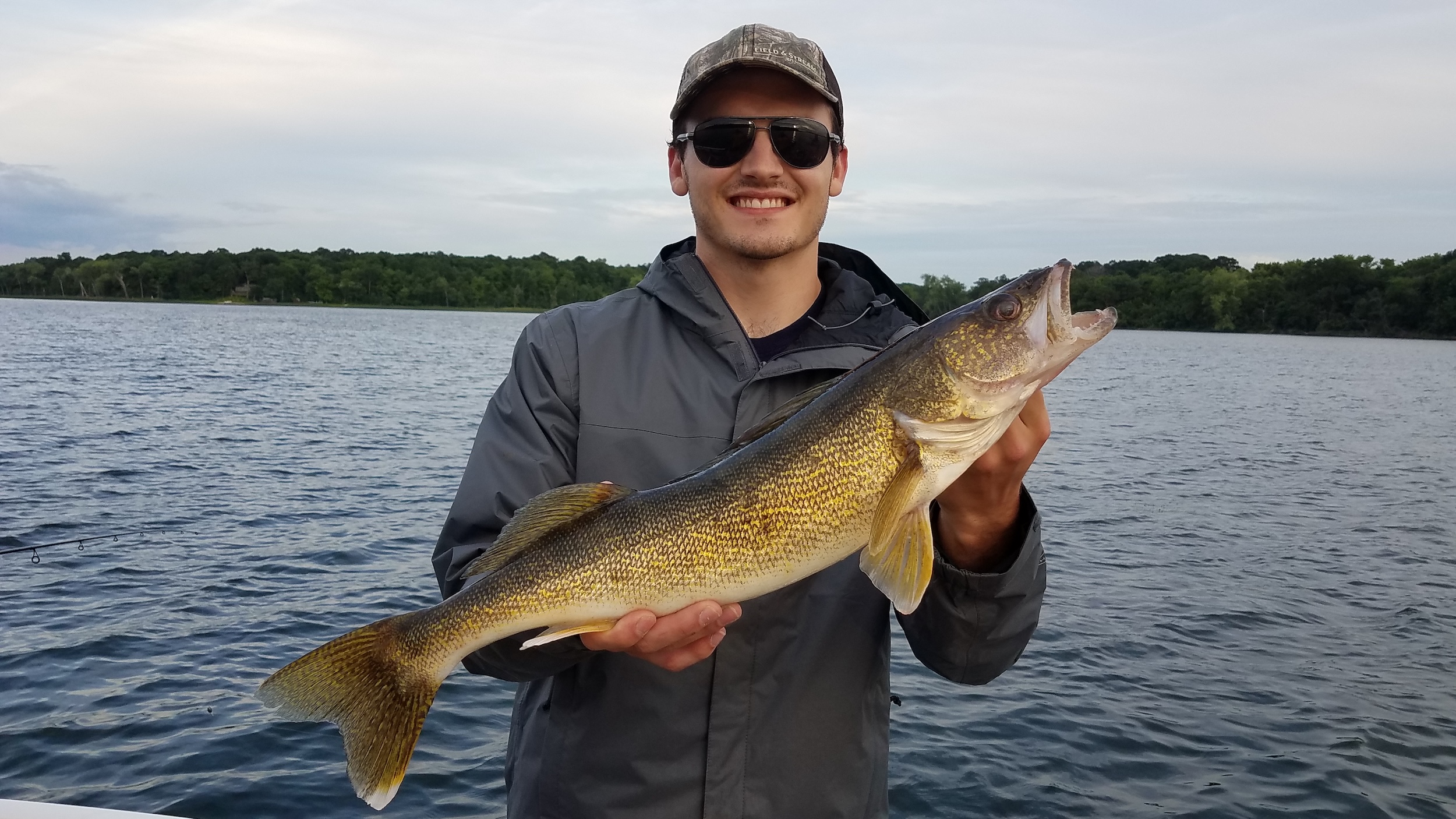 A fisherman holds a walleye in Maple Lake