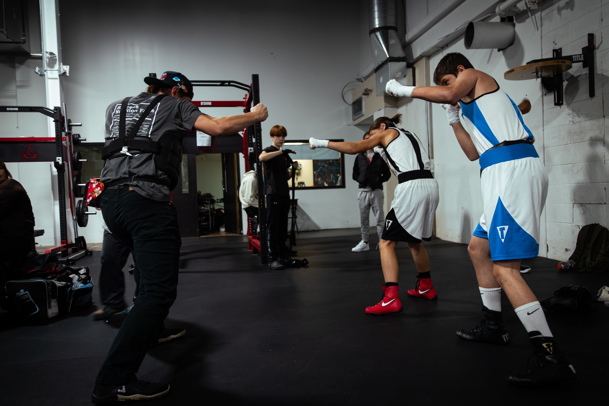 A couple boxers practice with a trainer at Element Gym