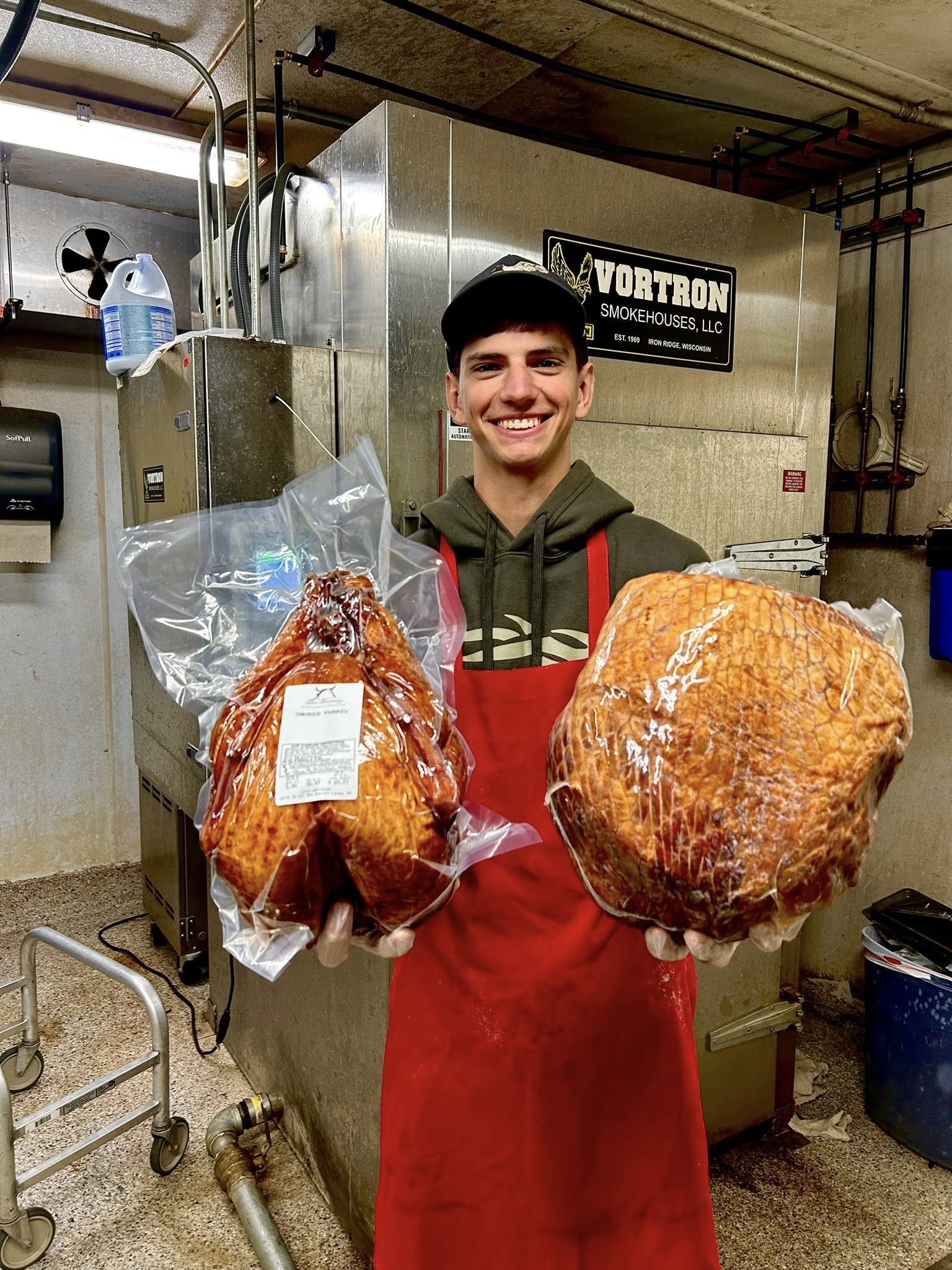 An employee holds smoked turkey at Lakes Processing