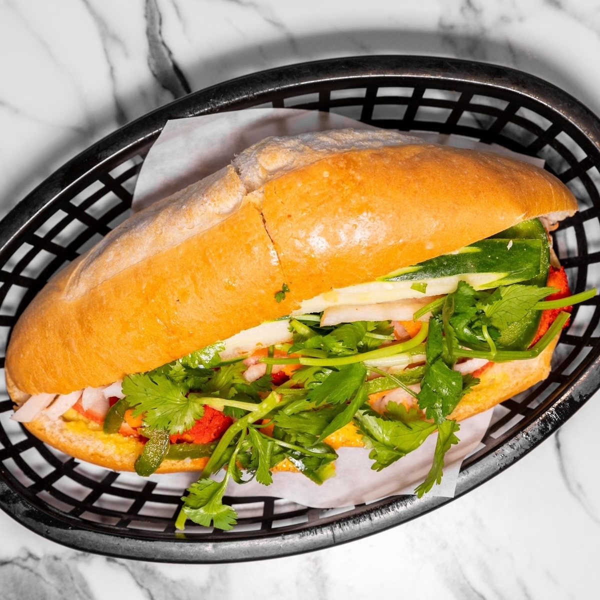 A bánh mì with red roast pork, pork loaf, meatballs, mayo and pâté