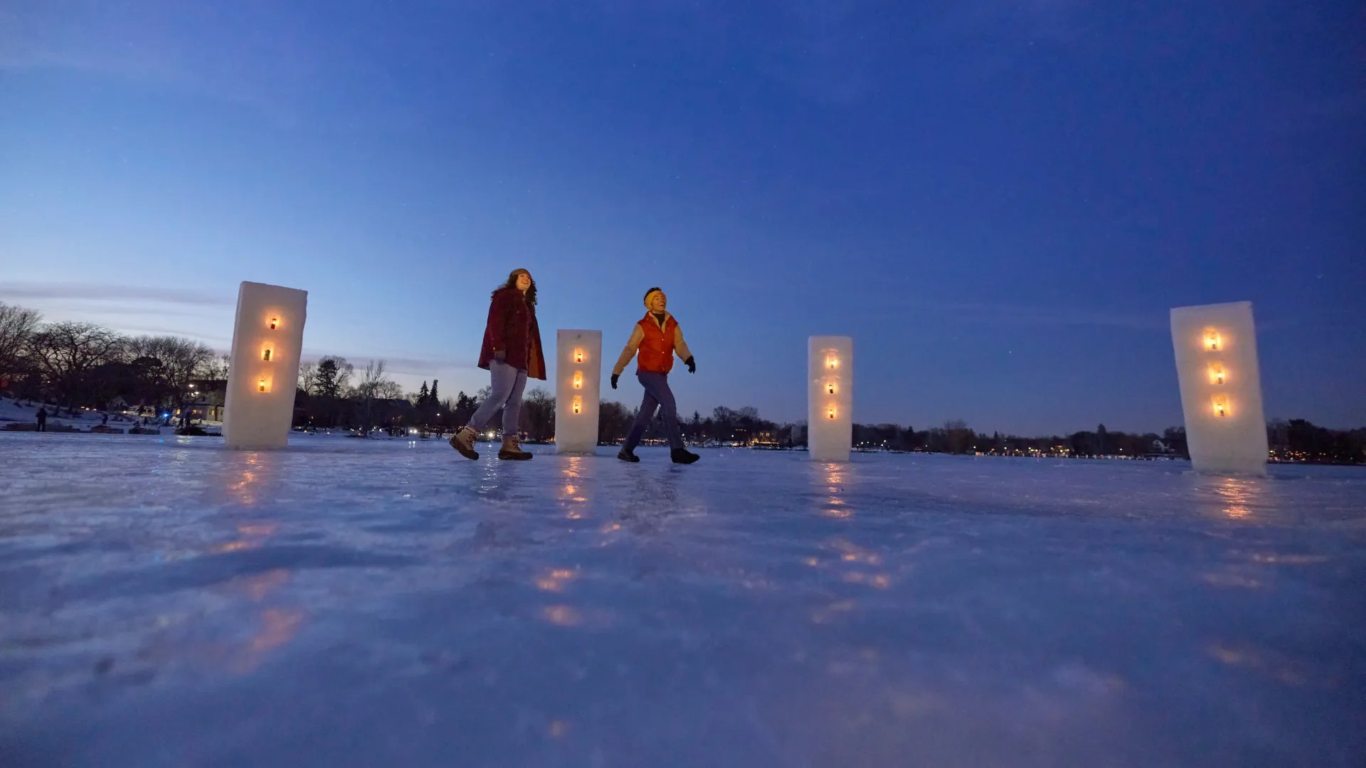 A couple friends walk along the Luminary Loppet in Minneapolis