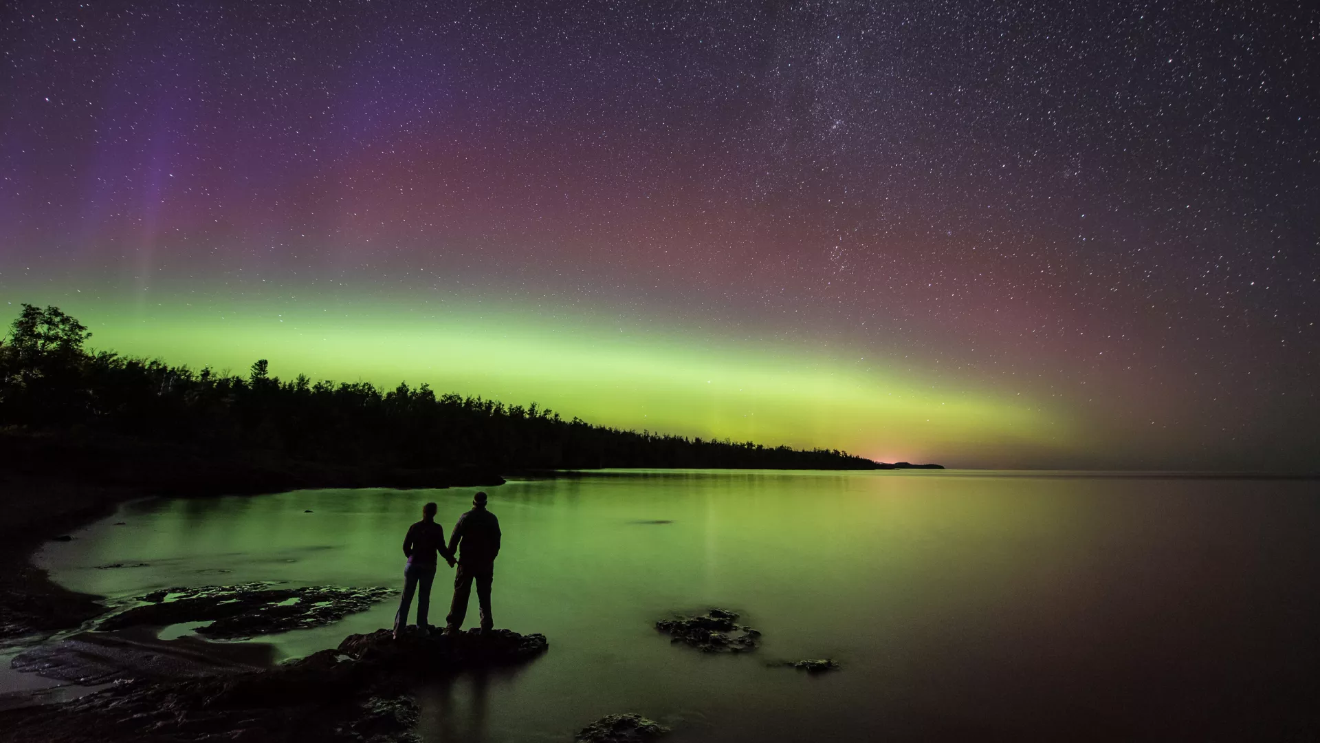 A couple watches the northern lights at Gooseberry Falls State Park