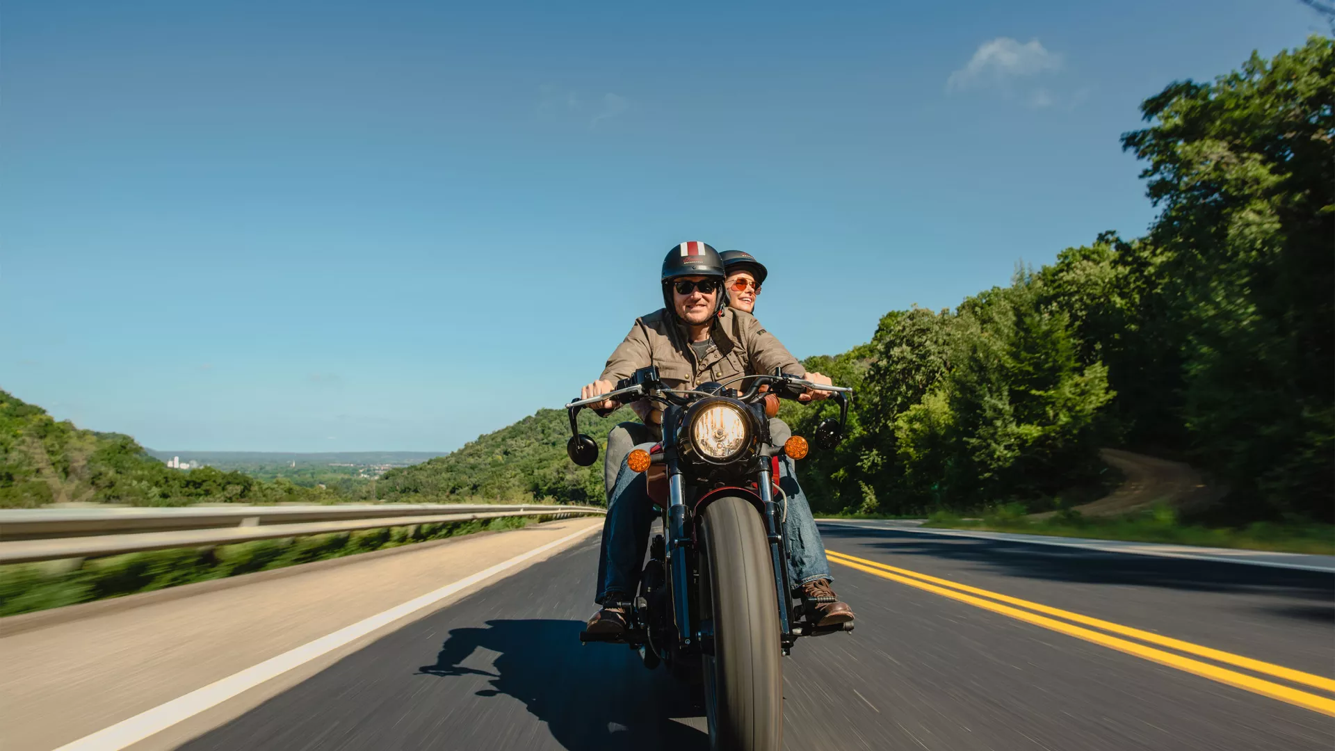Red wing smiling couple driving motorcycle