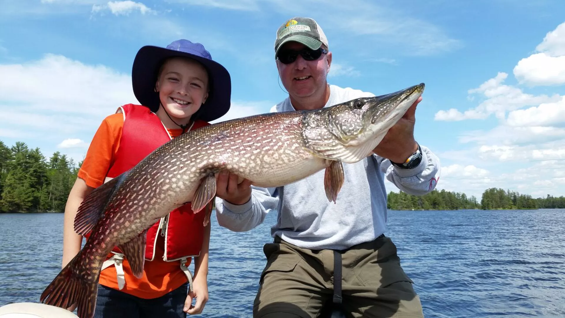 A young girl catches a nice northern pike while fishing in Voyageurs National Park