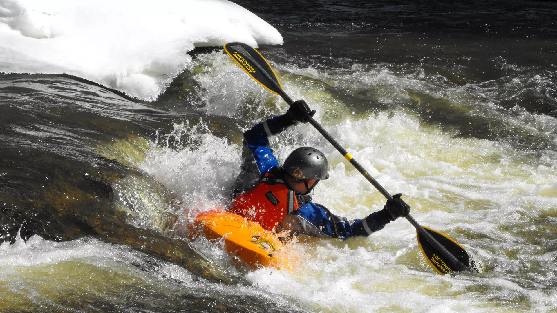 A kayaker takes advantage of the winter white caps as he navigates down the river