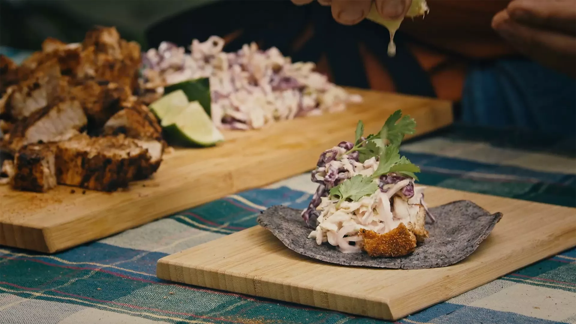 A swordfish taco with blue corn tortilla wrapper, slaw and cilantro garnish