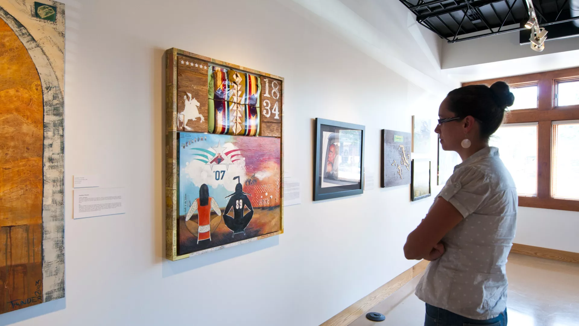 Woman looking at an exhibit at All My Relations Gallery