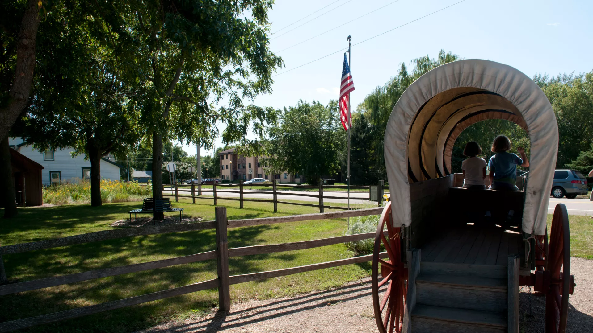 Kids playing in a covered wagon at the Laura Ingalls Wilder Museum
