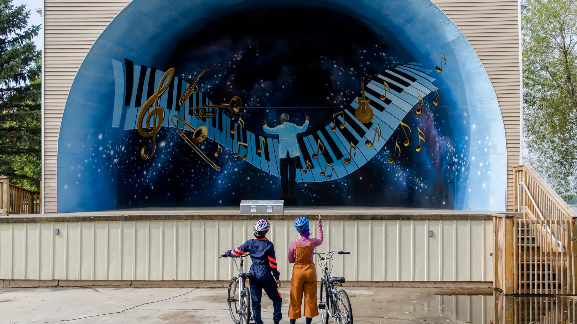 Two women biking, Sauk Centre bandshell, Lake Wobegon Trail
