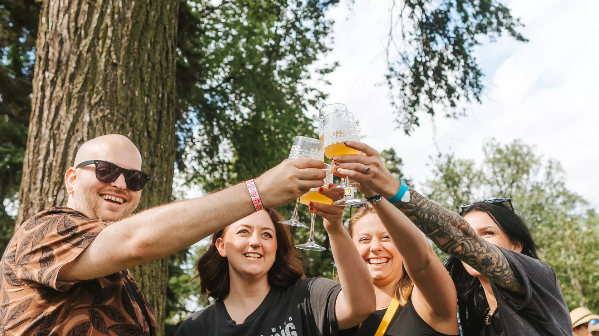 A group of friends raise their pint glasses at the Rare Beer Picnic