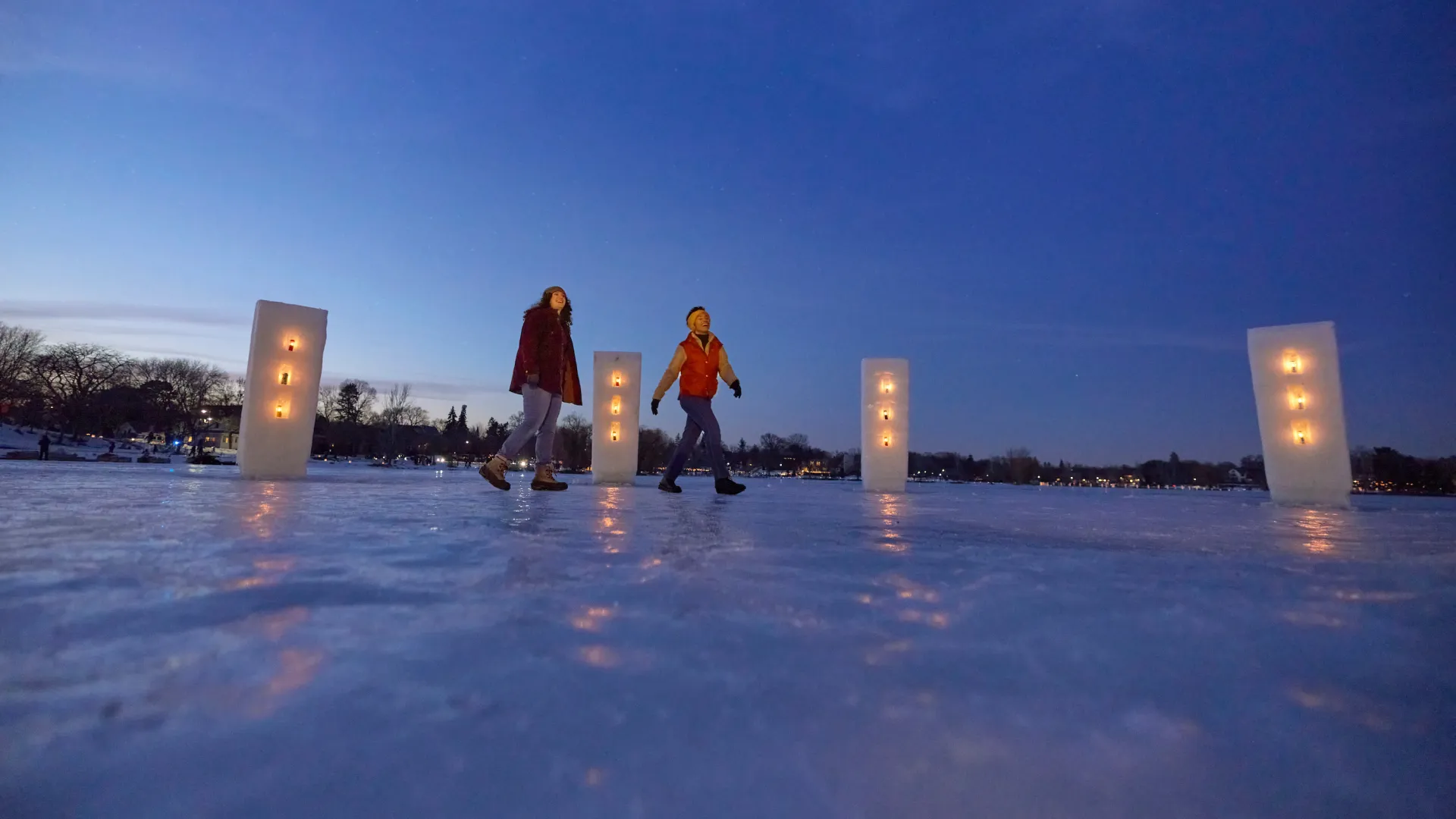 A couple friends walk along the Luminary Loppet in Minneapolis