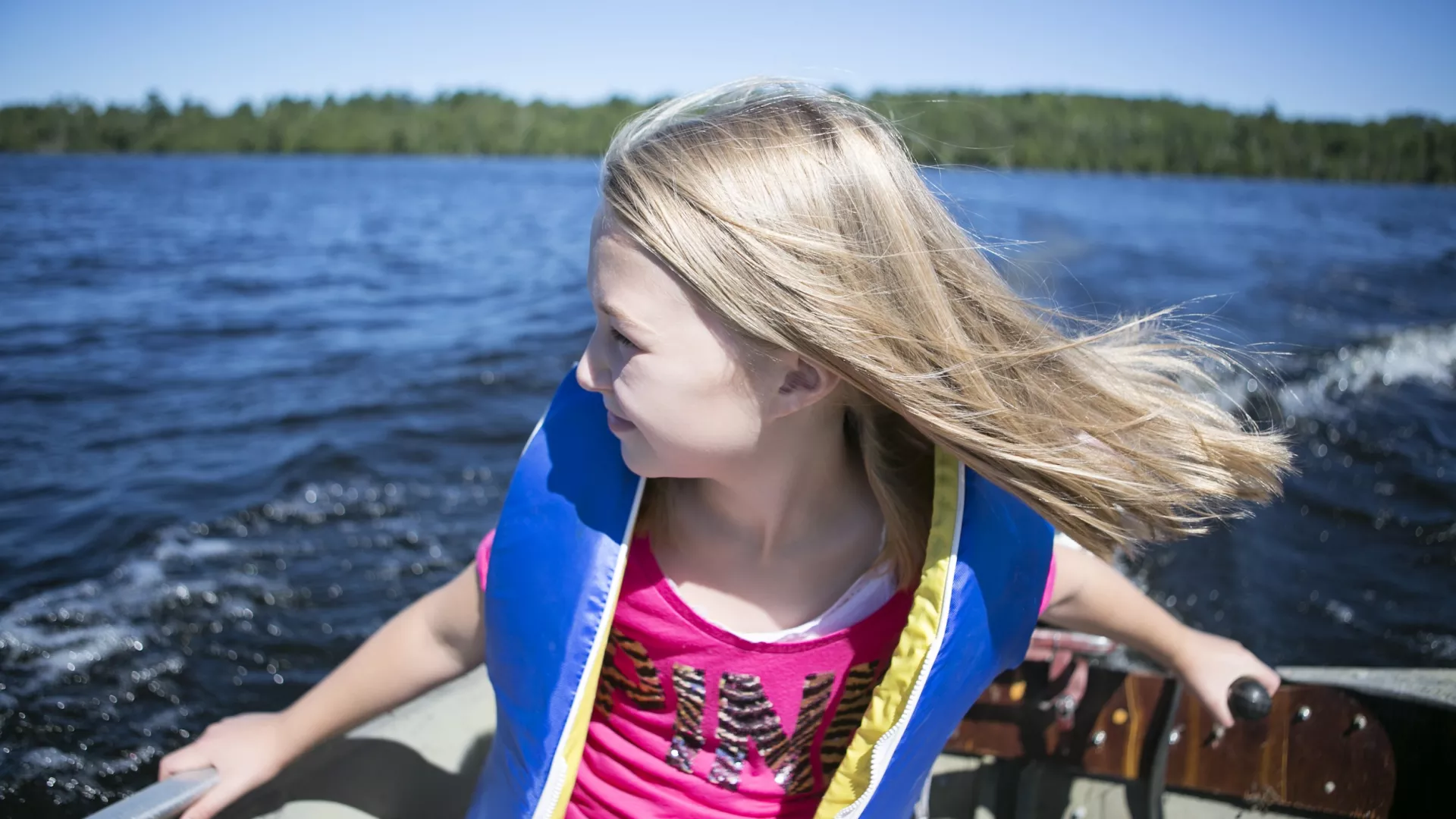 A girl learns how to drive a boat on Lake Vermilion