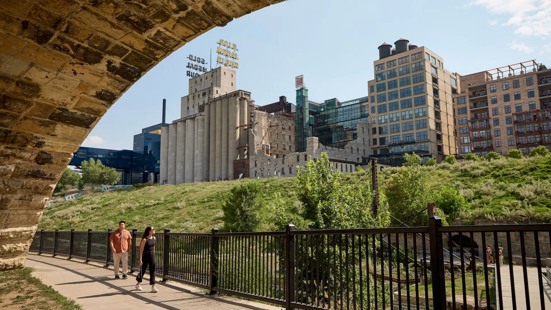 A couple friends walk along the Stone Arch Bridge