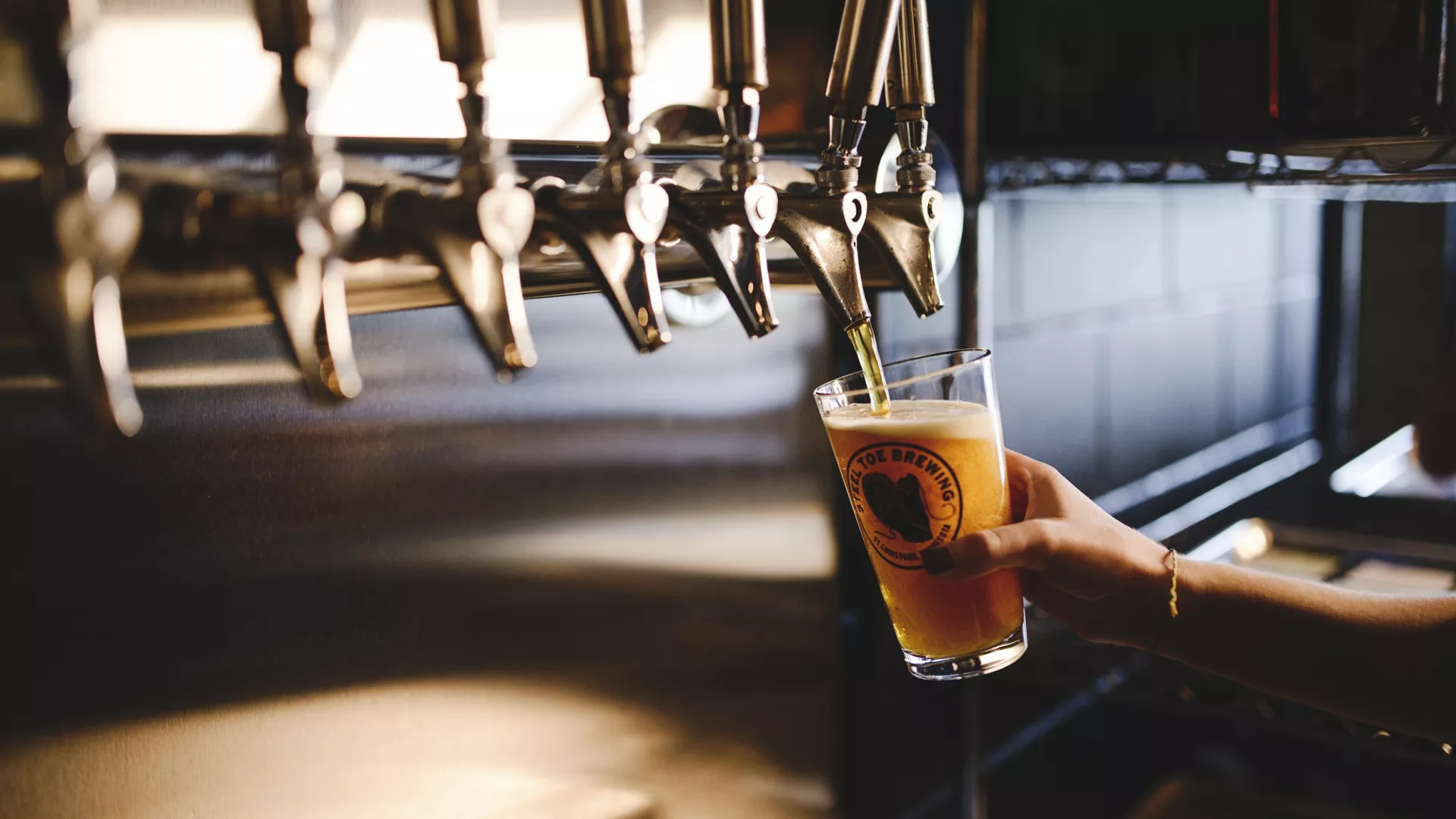 A bartender pours a pint at Steel Toe Brewing