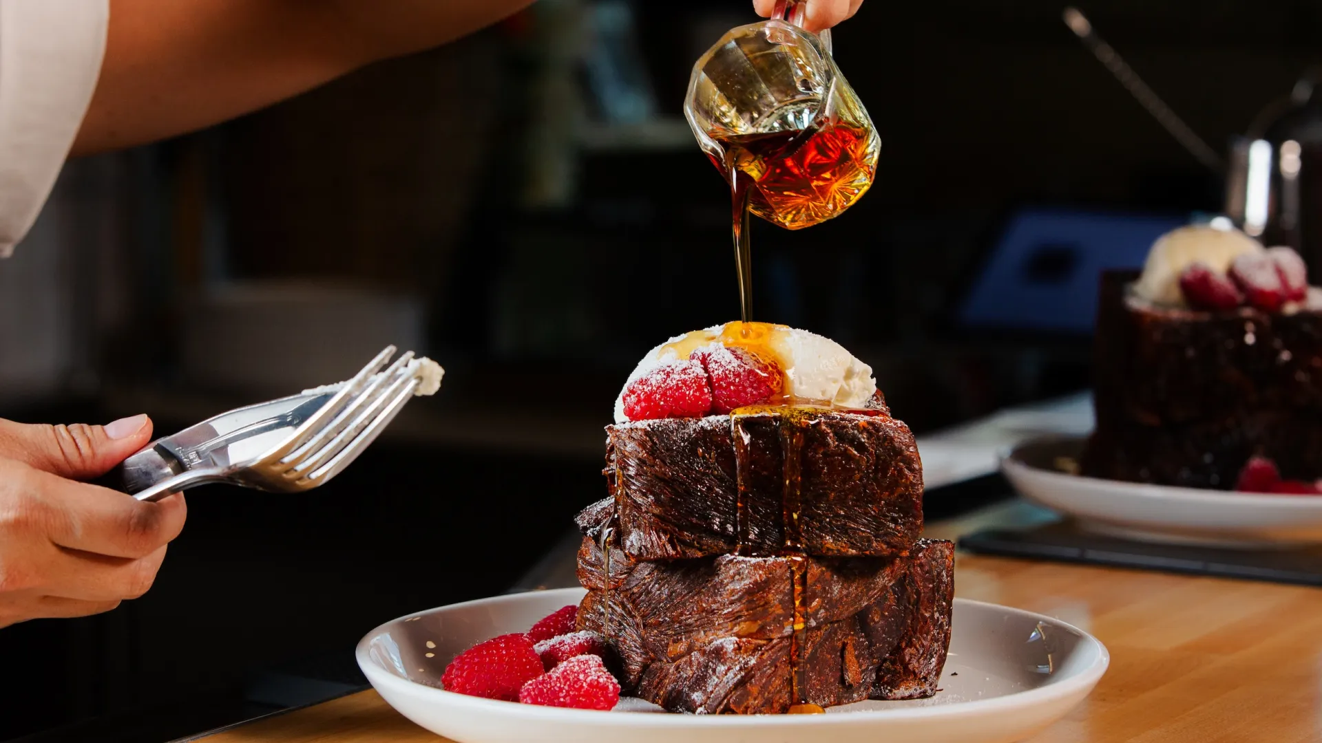Chef Diane Moua pours maple syrup on her Thai Tea French Toast