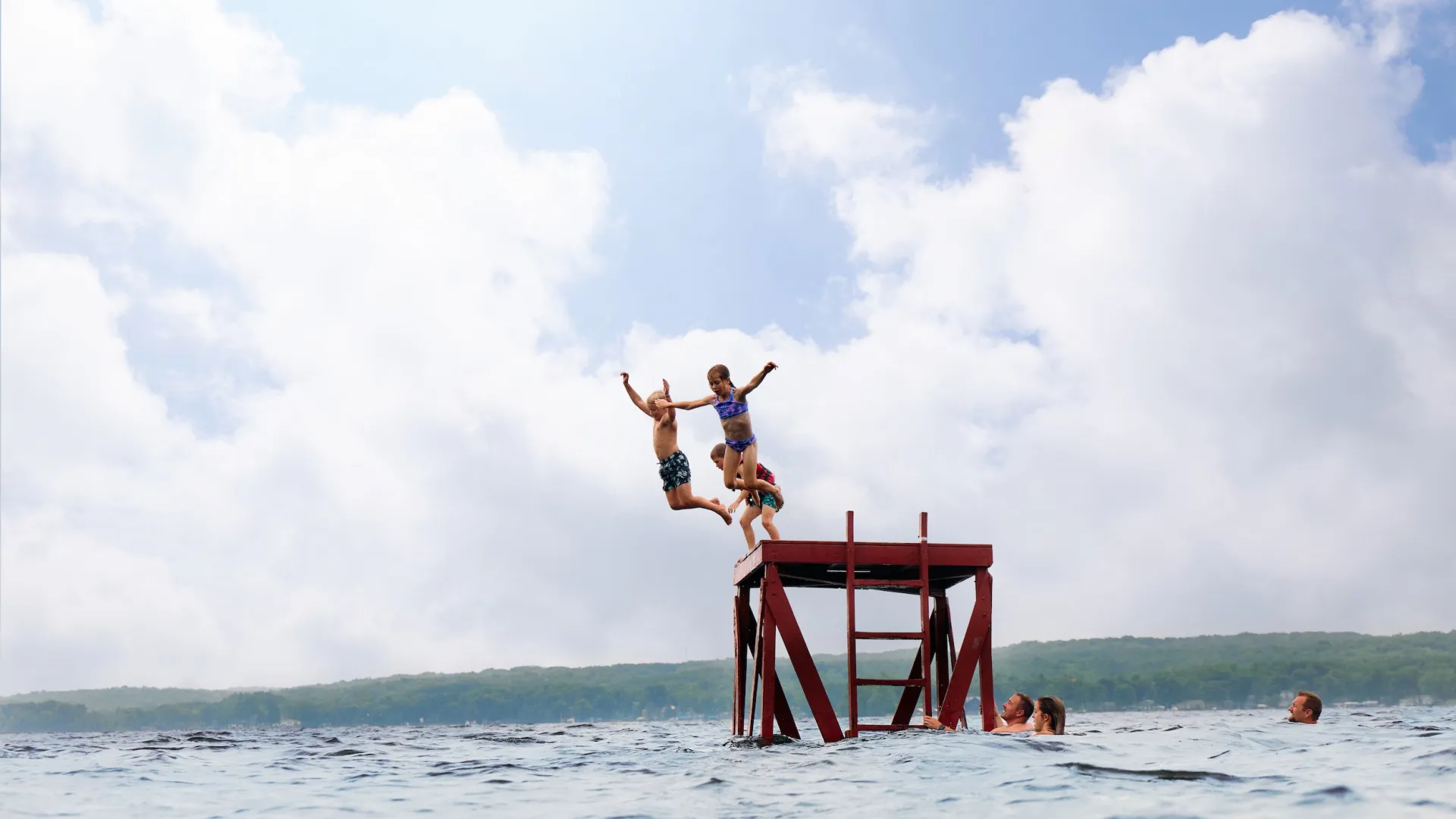 A family jumps into a lake at Fair Hills Resort