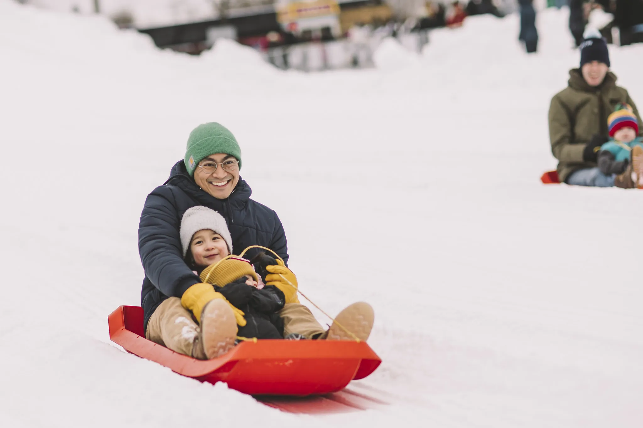 Dad and son on a sled at the Saint Paul Winter Carnival