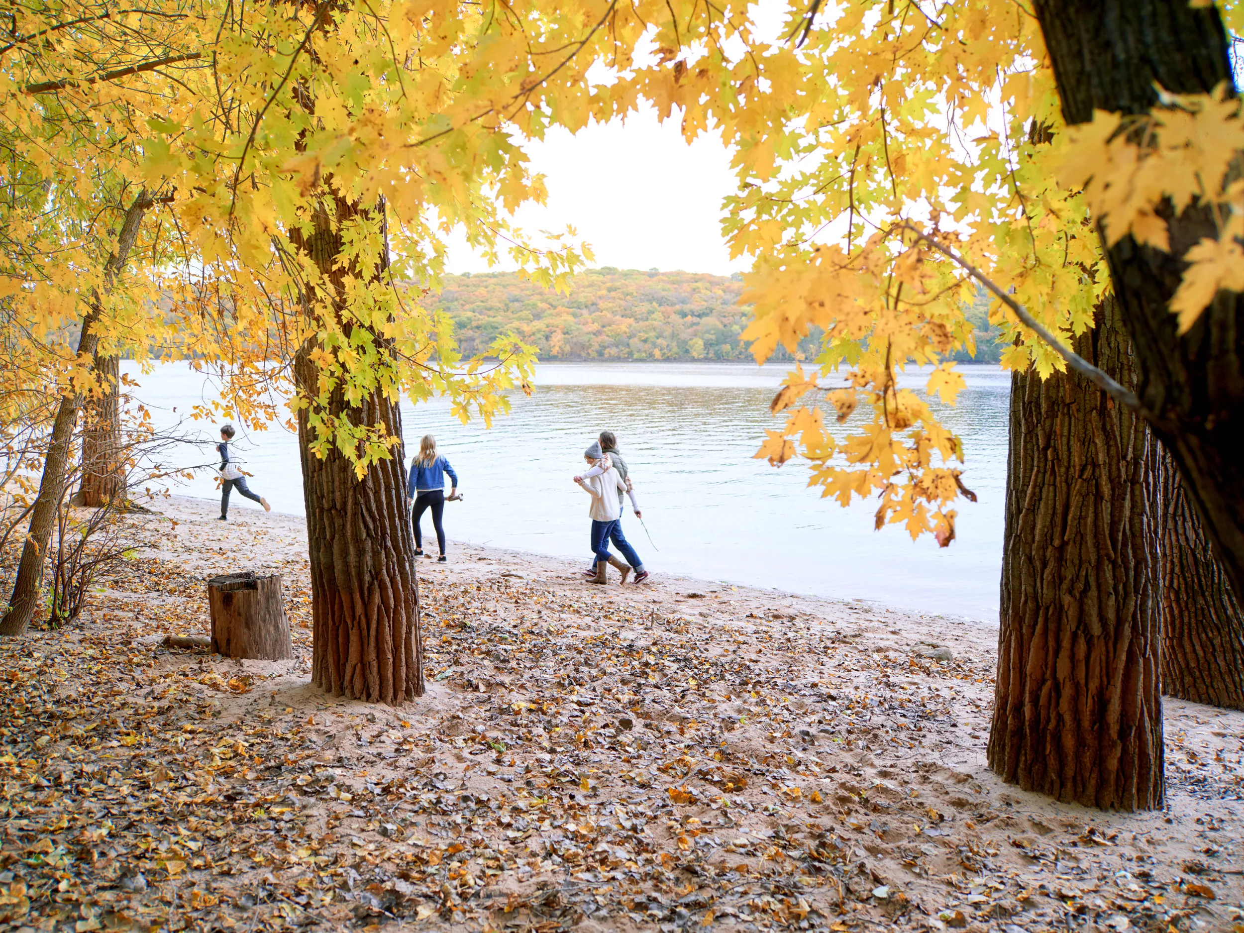 Family walks along river in fall