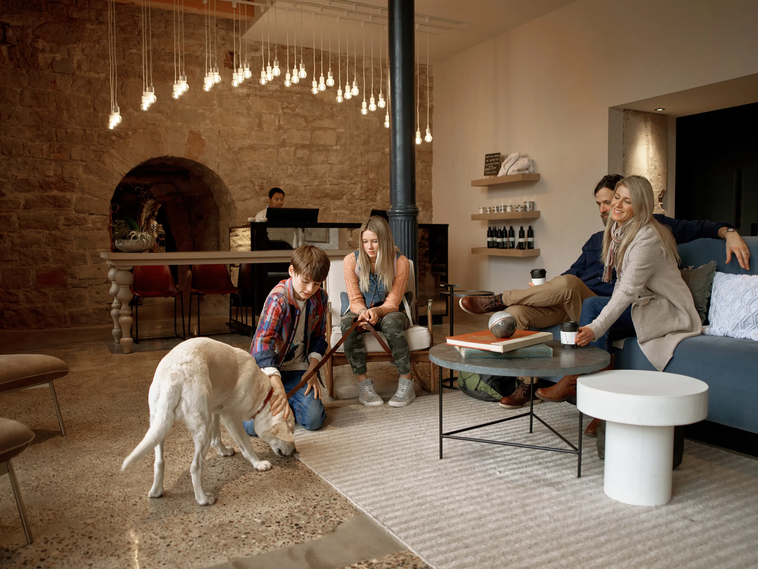 A family with their dog relax at the Lora Hotel in Stillwater