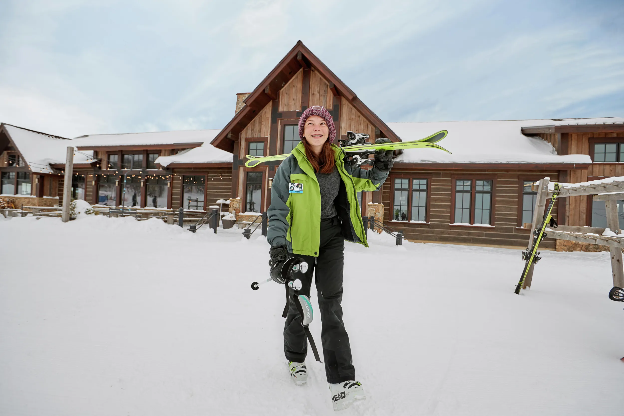 Teenager with skis outside lodge at Detroit Mountain ski area
