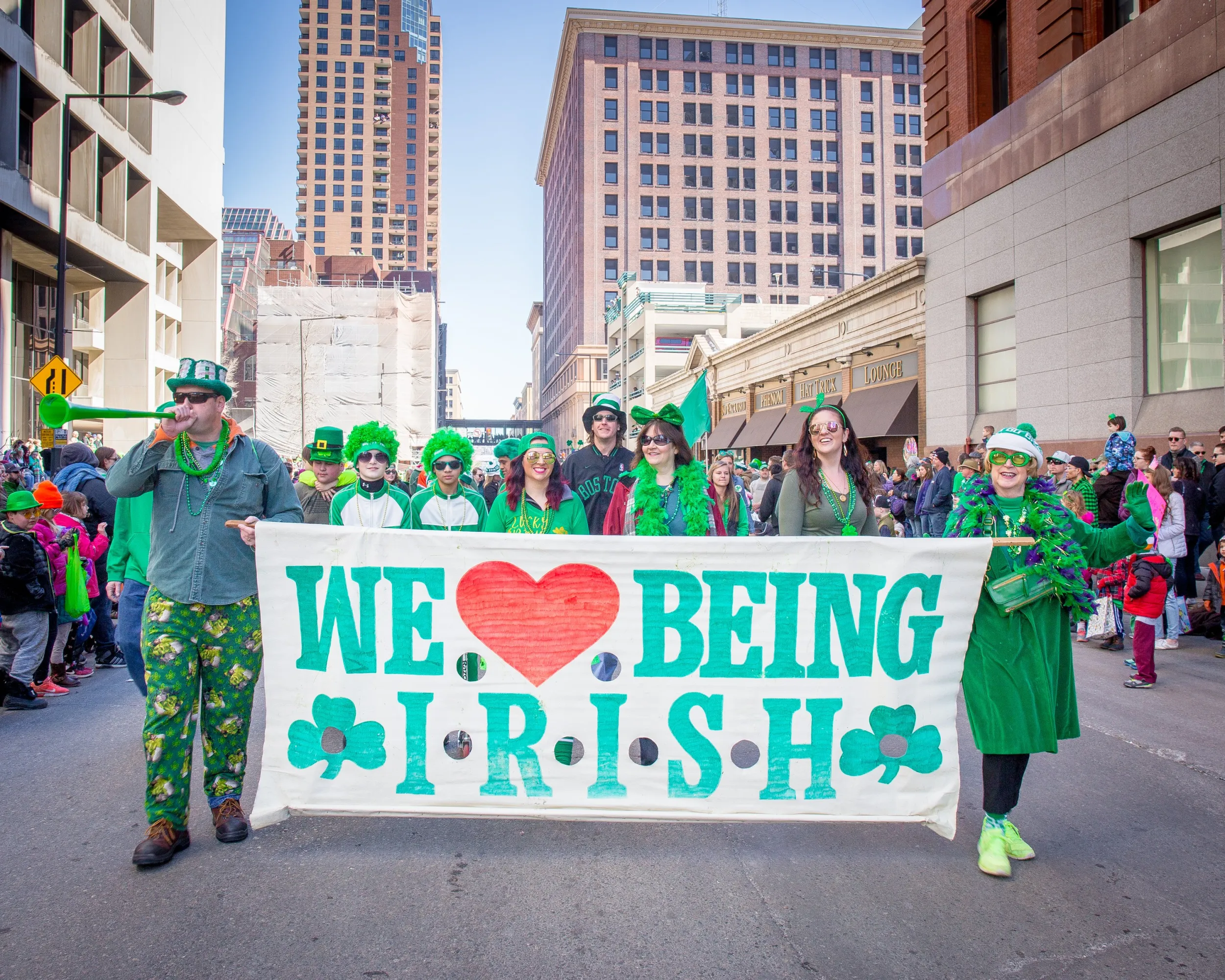 Parade-goers holding a "we love being Irish" banner