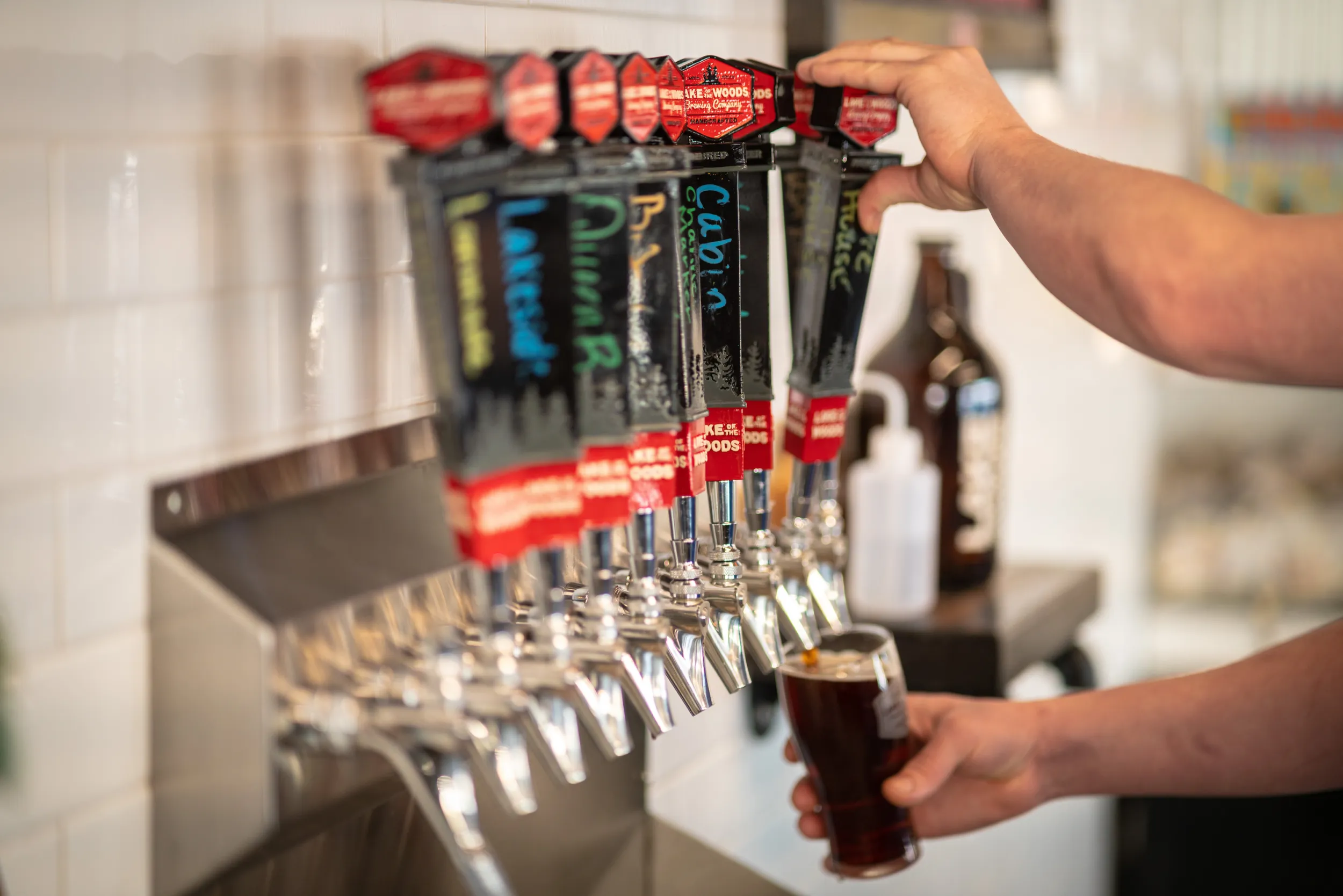 A bartender pulls a pint at Lake of the Woods Brewing Company