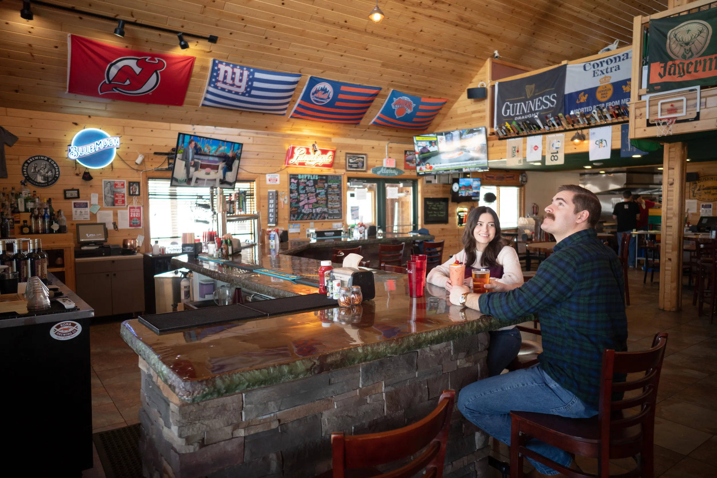 A couple sits at the bar of Nomad Tavern