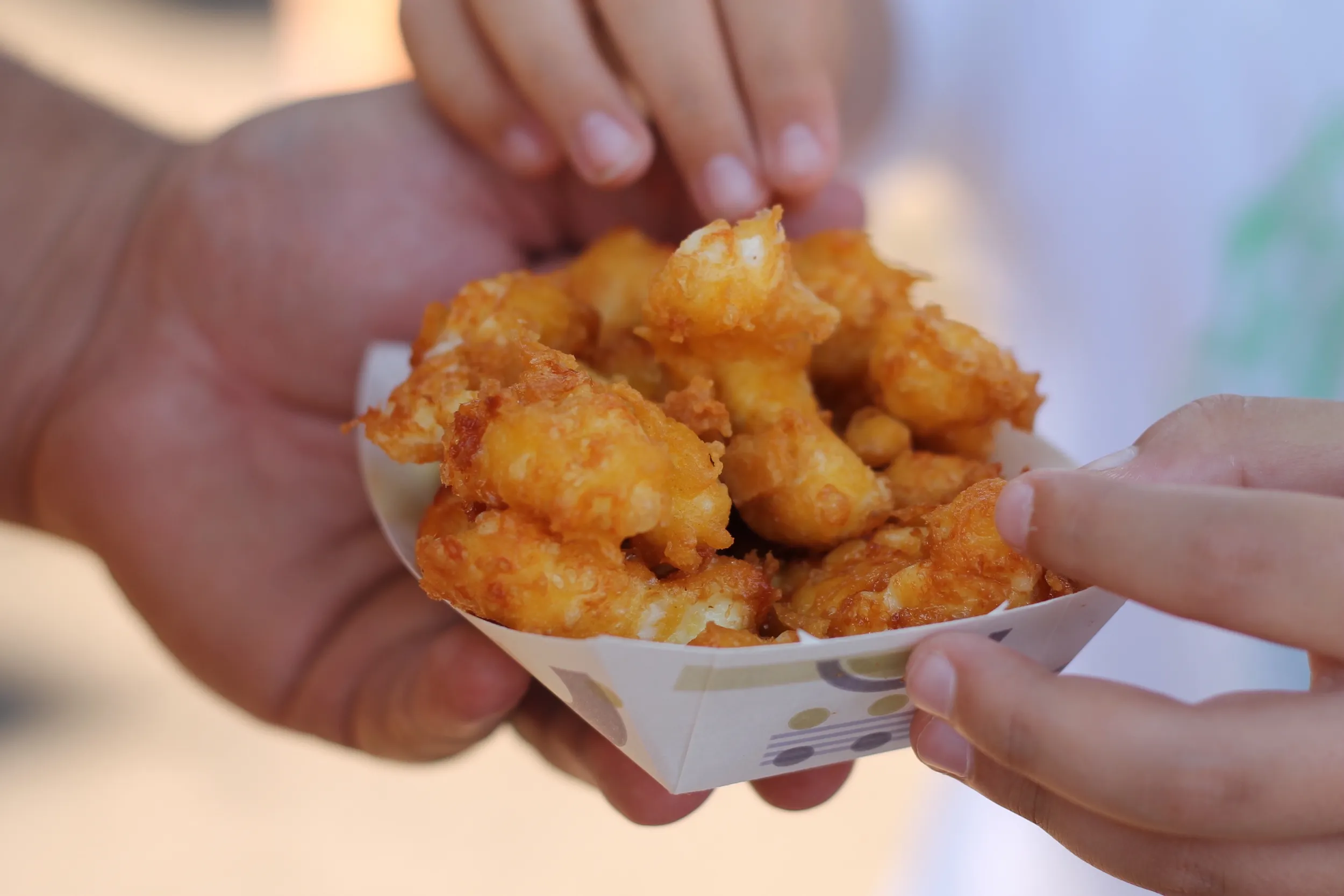 People sharing cheese curds at the Minnesota State Fair