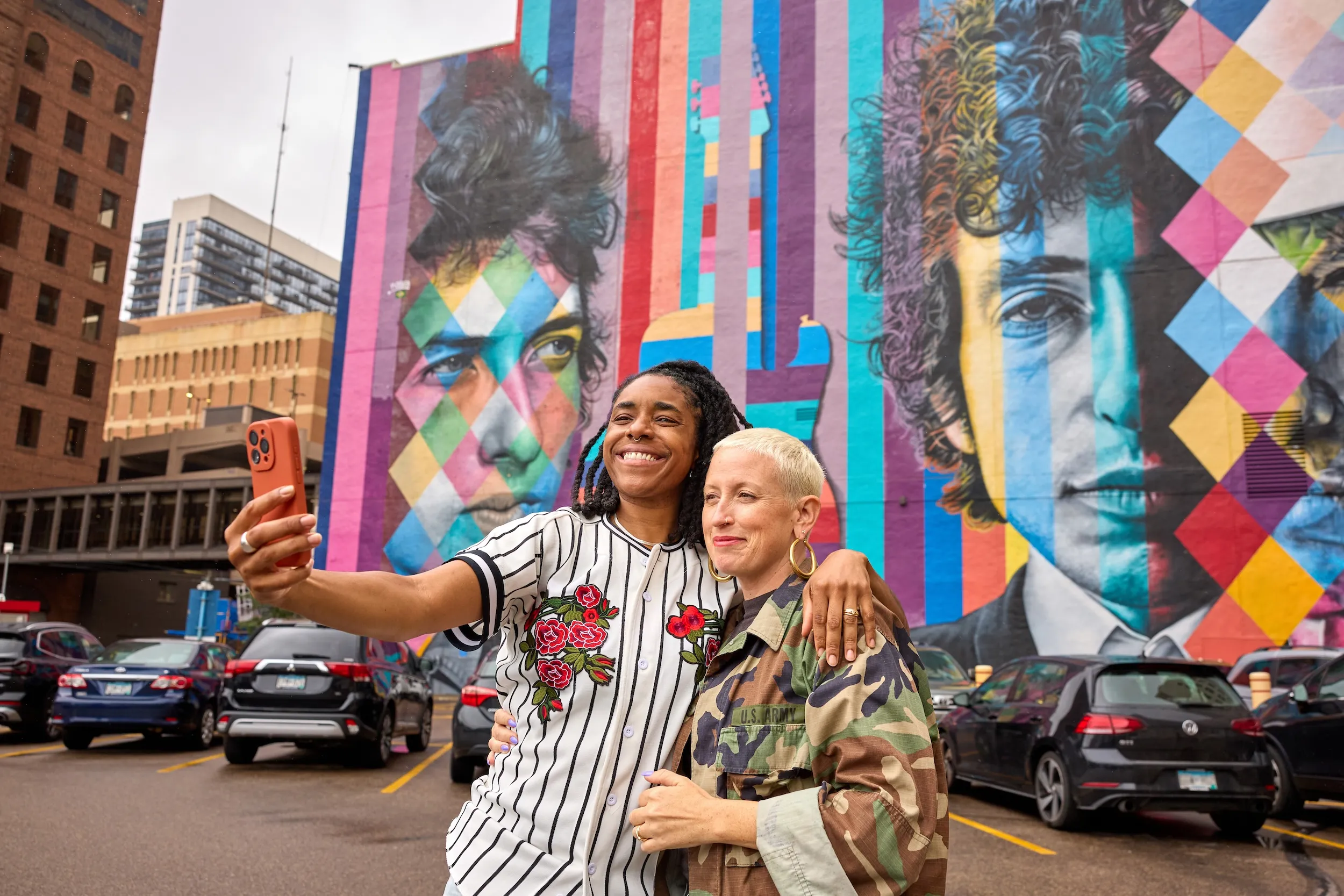 A couple takes their picture in front of the Bob Dylan mural in downtown Minneapolis